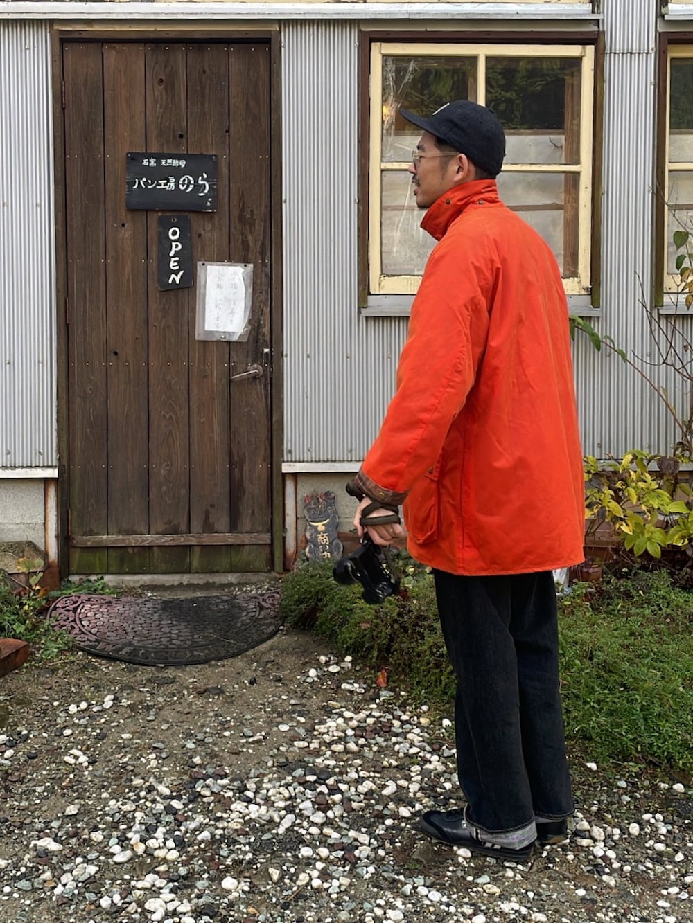 オレンジ系のジャケット/アウター、ブラック系のデニムパンツ、ブラック系のスニーカーを着用したメンズの冬コーディネートの2枚目の写真