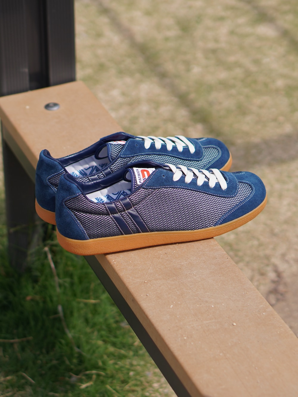 ベージュ系のチノパンツ、ホワイト系のトートバッグ、ブルー系のスニーカーを着用したメンズの春コーディネートの3枚目の写真