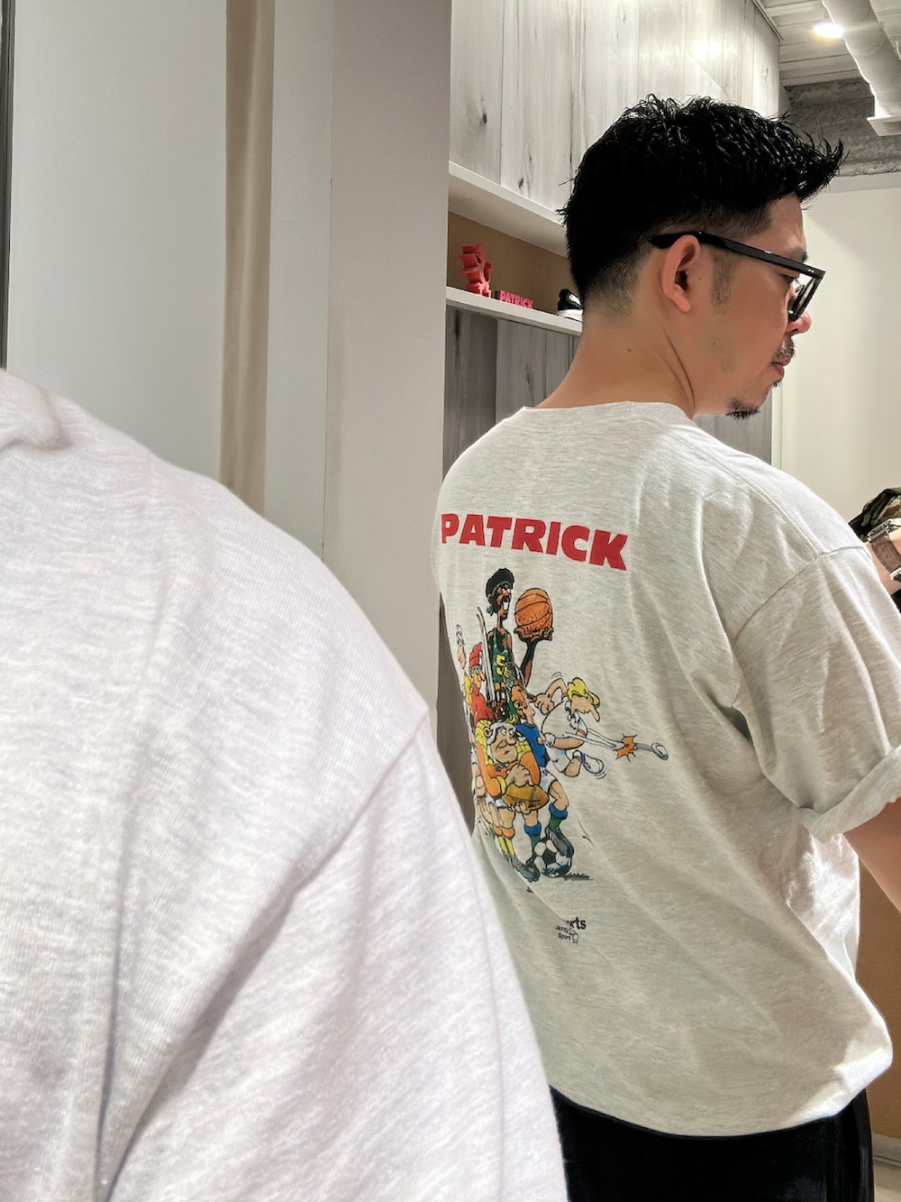 グレー系のTシャツ/カットソー、ブルー系のパンツ、ブラック系のスニーカーを着用したメンズの夏コーディネートの2枚目の写真