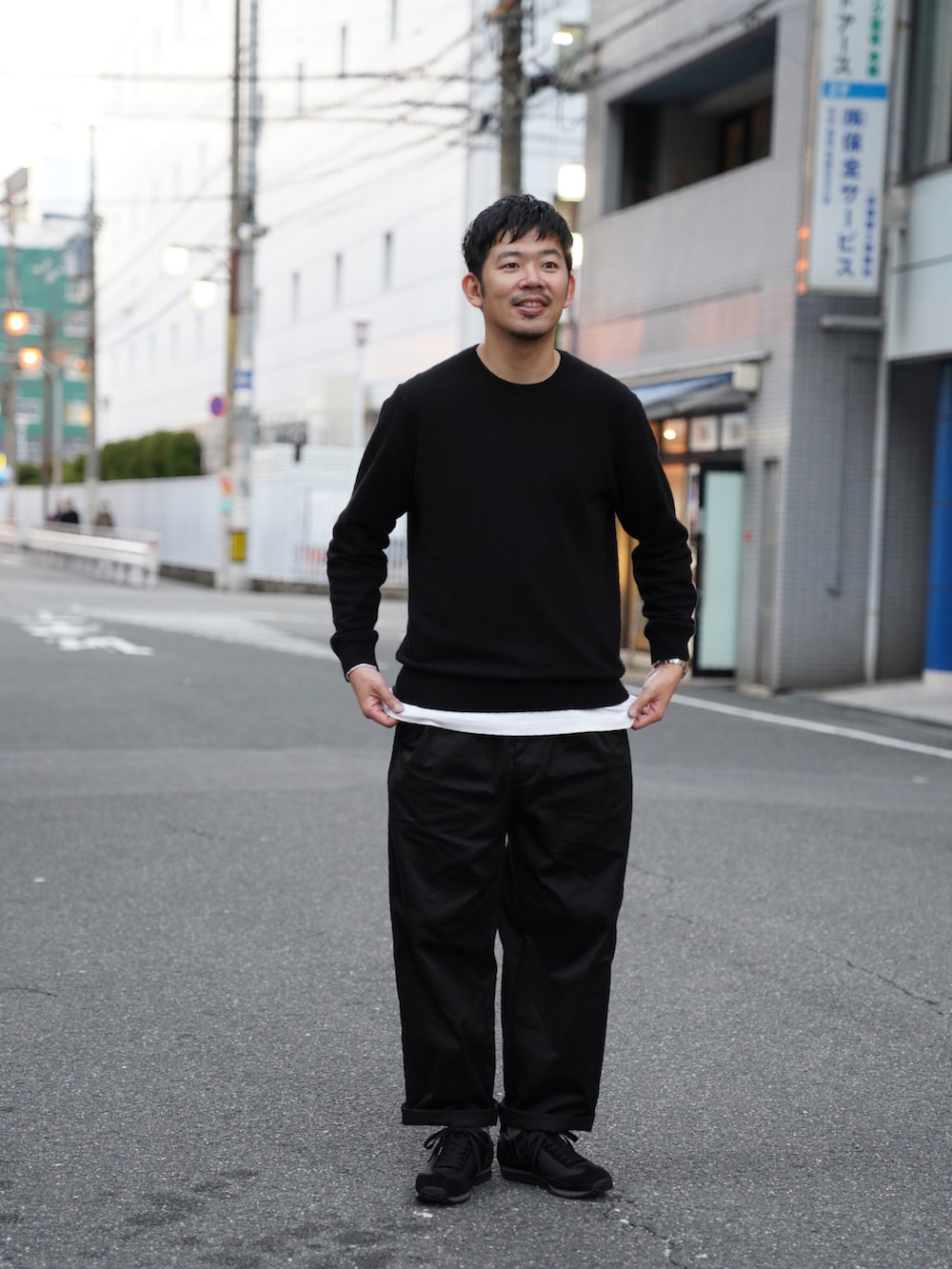 グリーン系のジャケット/アウター、ブラック系のニット/セーター、ブラック系のチノパンツを着用したメンズの冬コーディネートの2枚目の写真