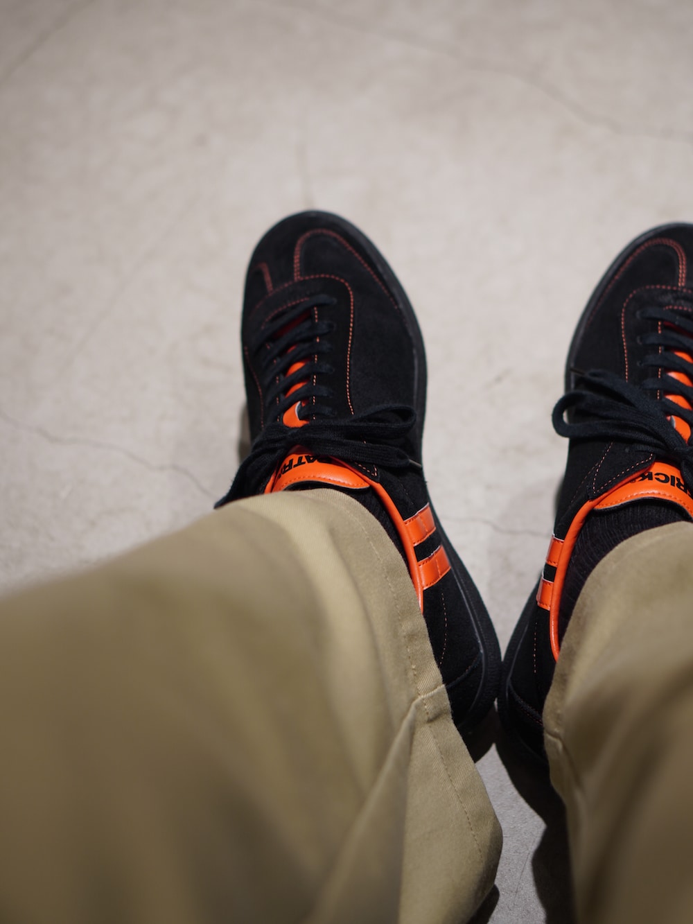 ブルー系のデニムジャケット、ベージュ系のチノパンツ、ブラック系のスニーカーを着用したメンズの秋コーディネートの2枚目の写真