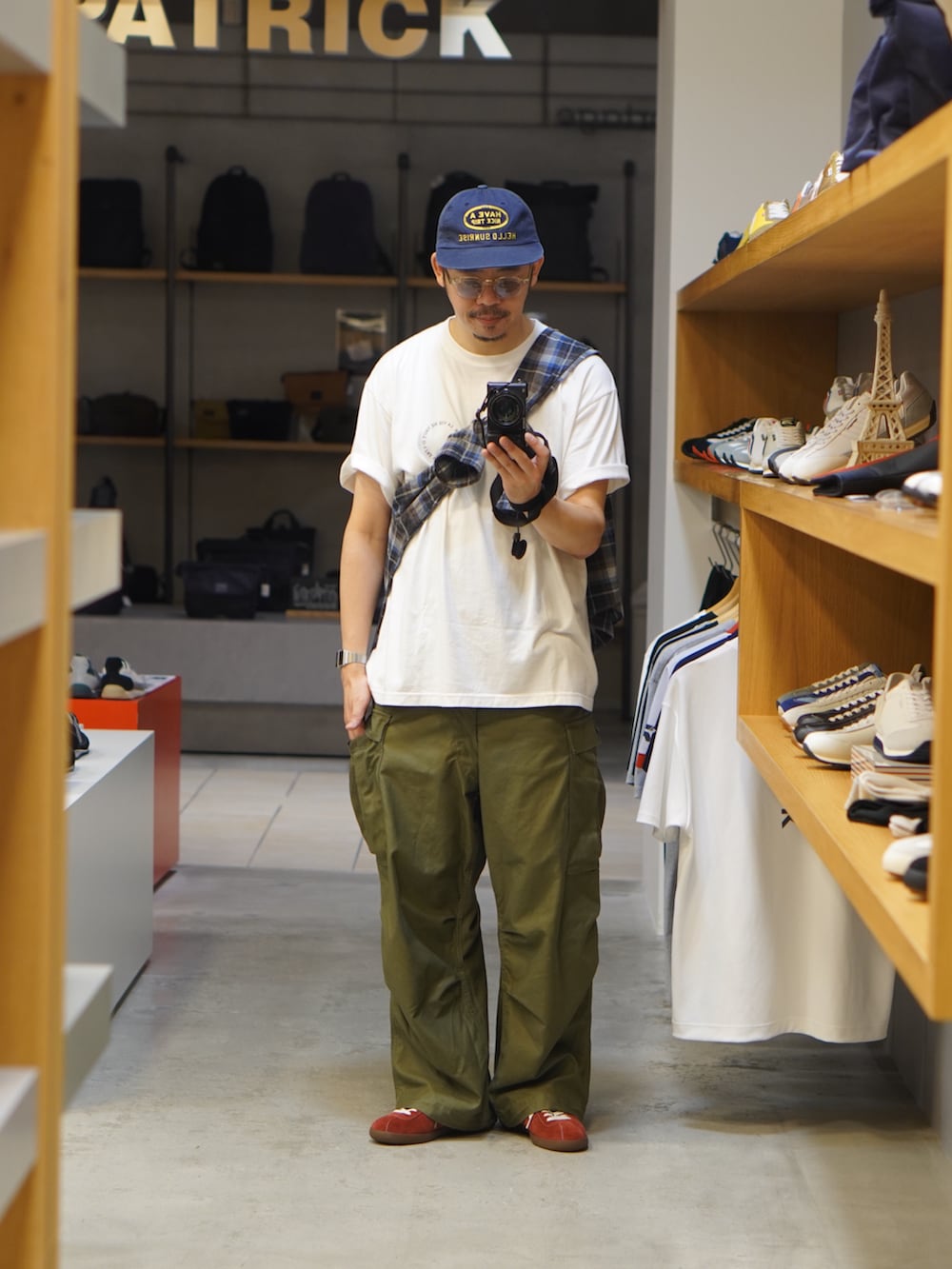 ホワイト系のTシャツ/カットソー、ブルー系のシャツ/ブラウス、グリーン系のカーゴパンツを着用したメンズの秋コーディネートの2枚目の写真