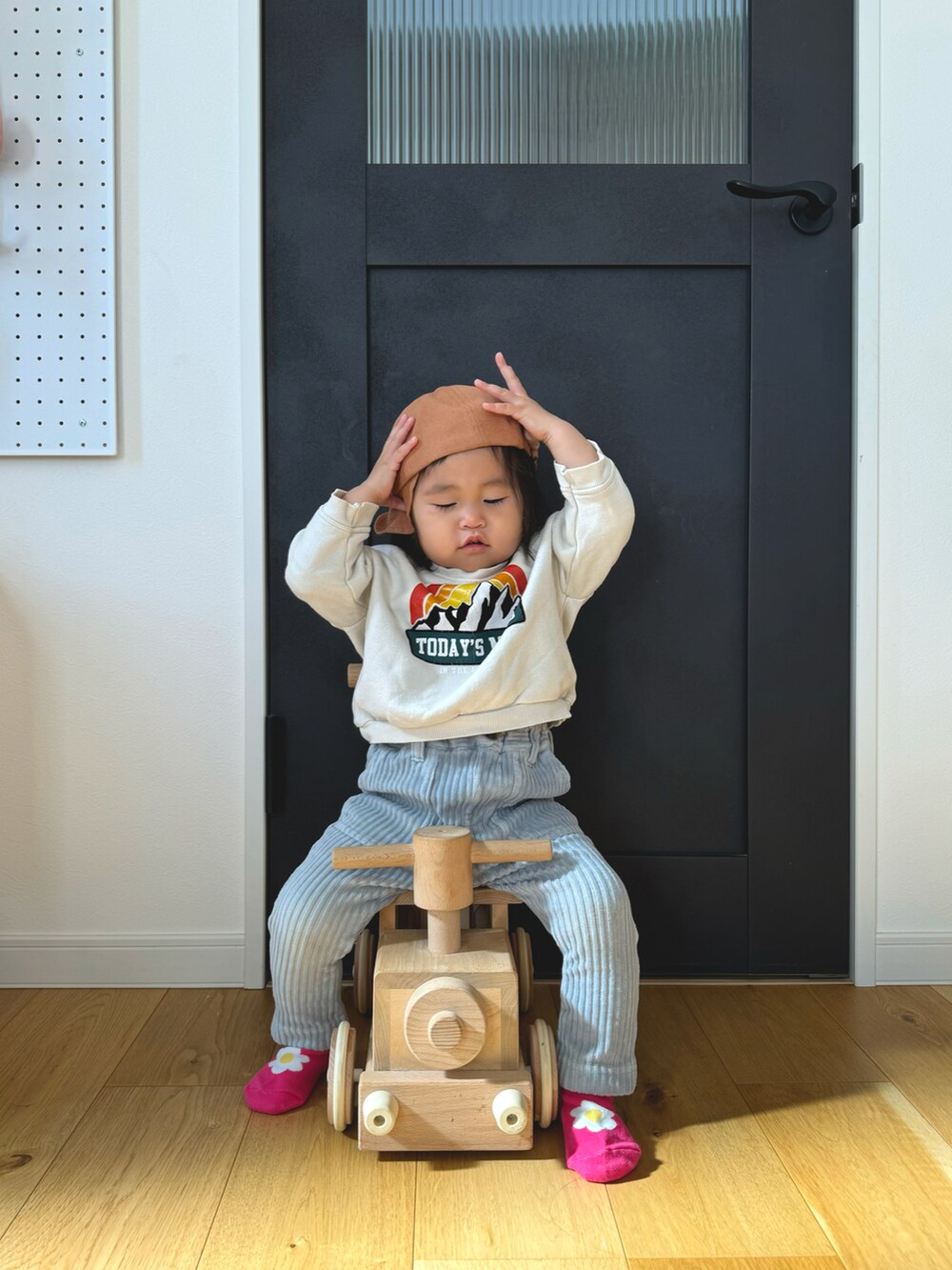 ホワイト系のスウェット、ブルー系のその他パンツ、オレンジ系のキャップを着用したキッズの冬コーディネートの3枚目の写真