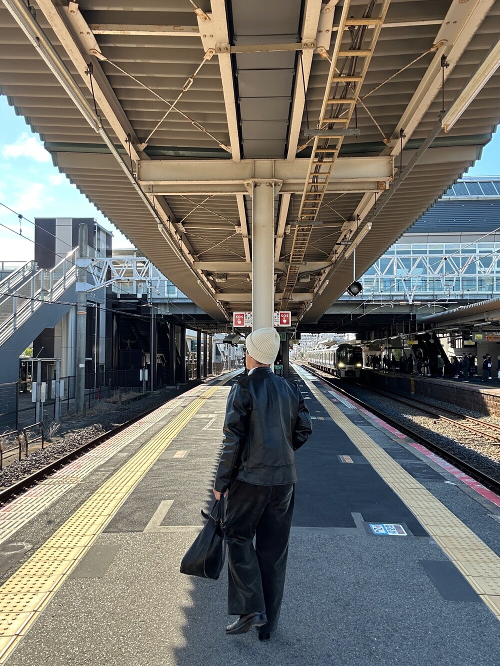 グリーン系のその他パンツ、グレー系のポロシャツ、ブラック系のライダースジャケットを着用したメンズの秋コーディネートの3枚目の写真