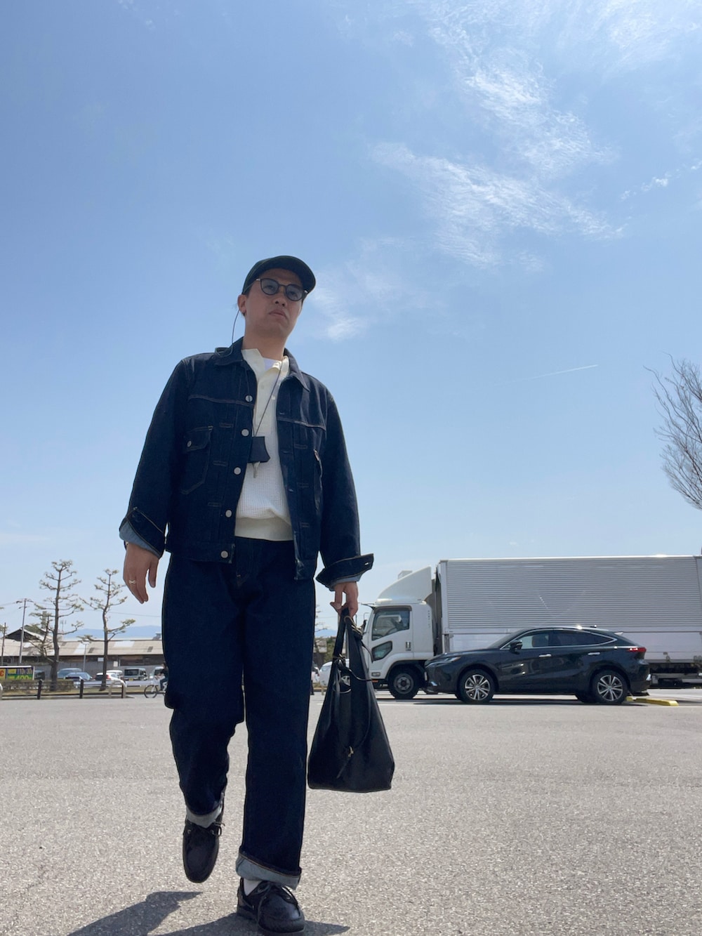 ホワイト系のTシャツ/カットソー、ブラック系のショルダーバッグ、ブルー系のデニムパンツを着用したメンズの春コーディネートの3枚目の写真