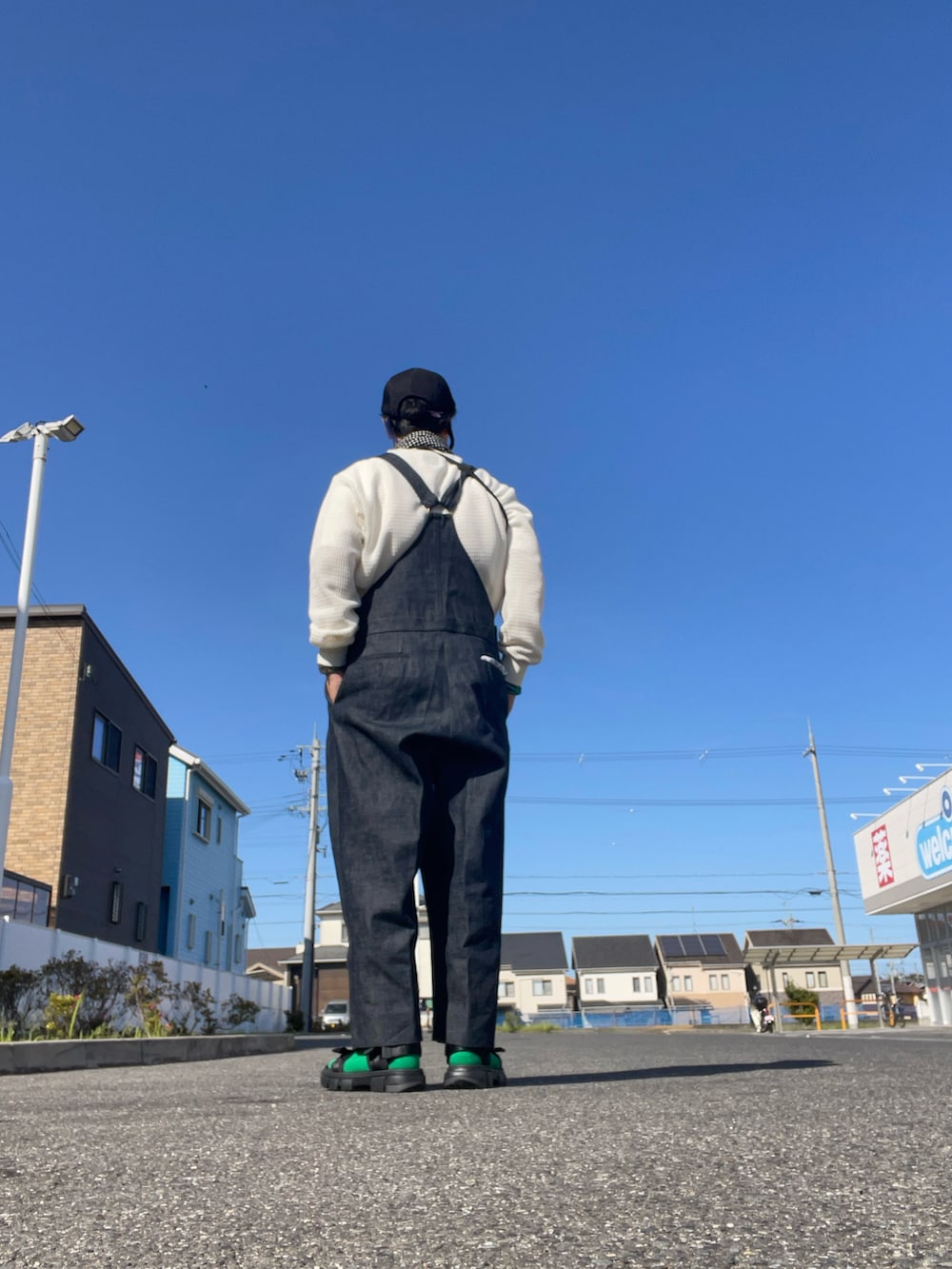 ブラック系のサロペット/オーバーオール、ホワイト系のTシャツ/カットソー、グリーン系のショルダーバッグを着用したメンズの春コーディネートの2枚目の写真