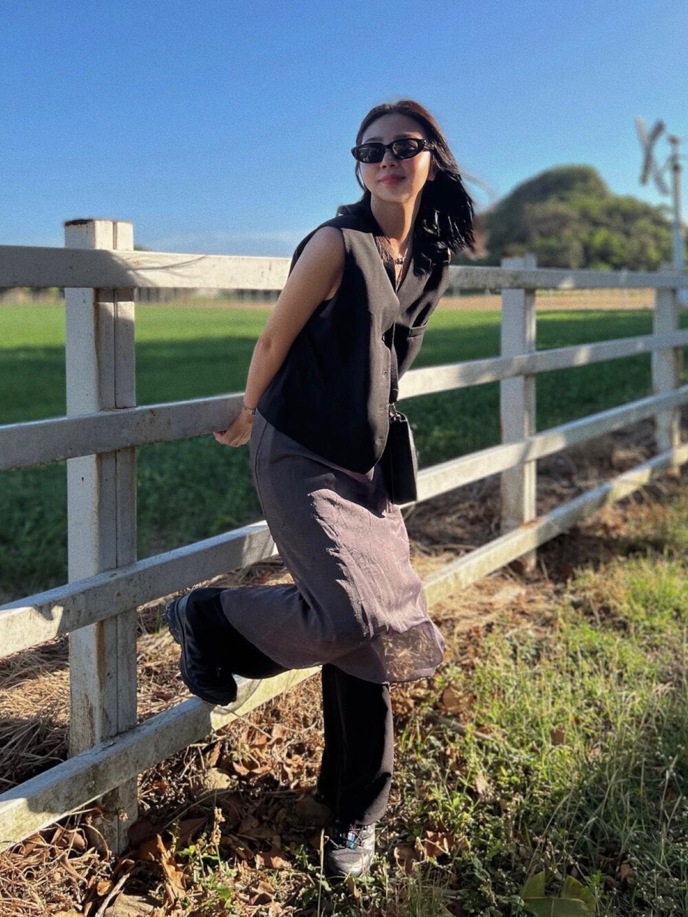 ブラック系のショルダーバッグ、ブラック系のスニーカー、グレー系のワンピースを着用したレディースの冬コーディネートの3枚目の写真