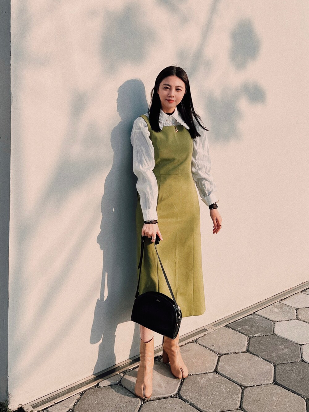 グリーン系のワンピース、ホワイト系のシャツ/ブラウス、ブラック系のショルダーバッグを着用したレディースの冬コーディネートの2枚目の写真