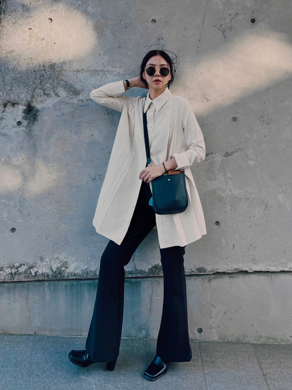 ブラック系のブーツ、ブラック系のスラックス、ホワイト系のシャツ/ブラウスを着用したレディースの冬コーディネートの2枚目の写真