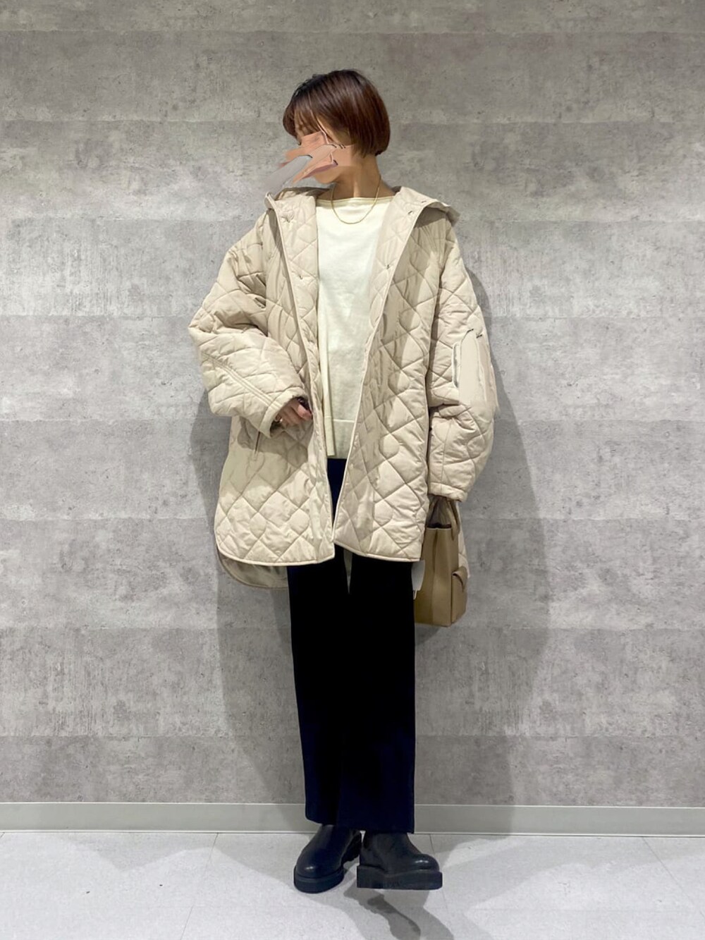 ベージュ系のダウンジャケット/コート、ブラック系のその他パンツ、ブラック系のブーツを着用したレディースの冬コーディネートの2枚目の写真