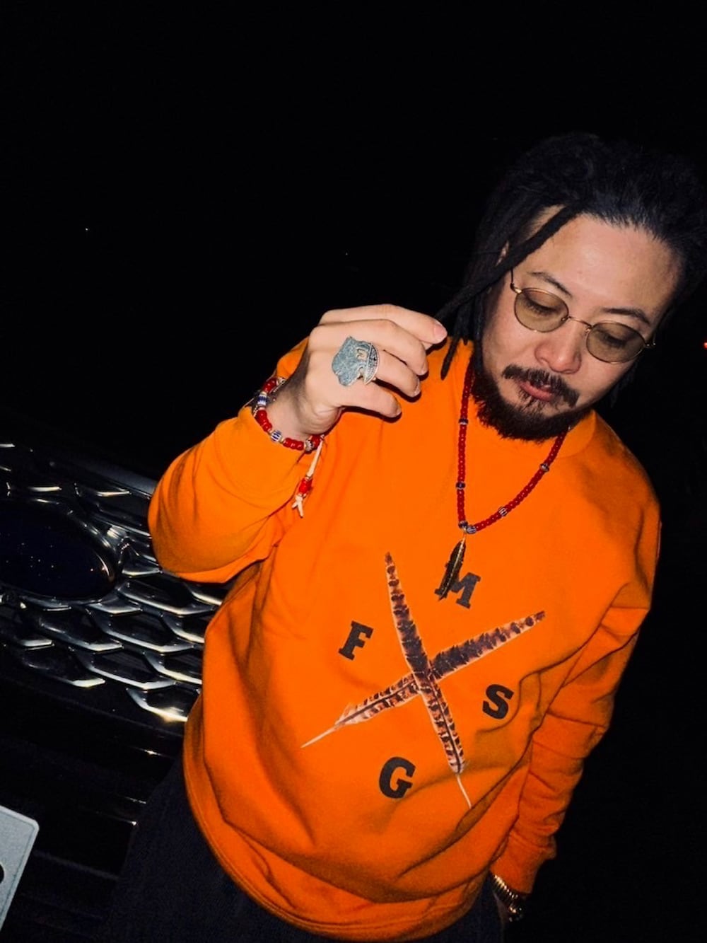 オレンジ系のスウェットを着用したレディースの春コーディネートの3枚目の写真