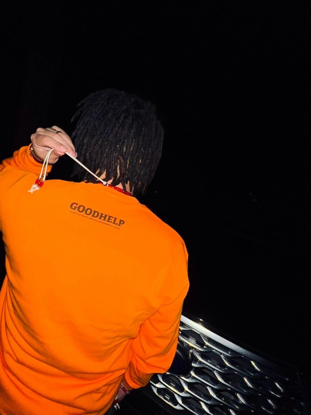 オレンジ系のスウェットを着用したレディースの春コーディネートの2枚目の写真