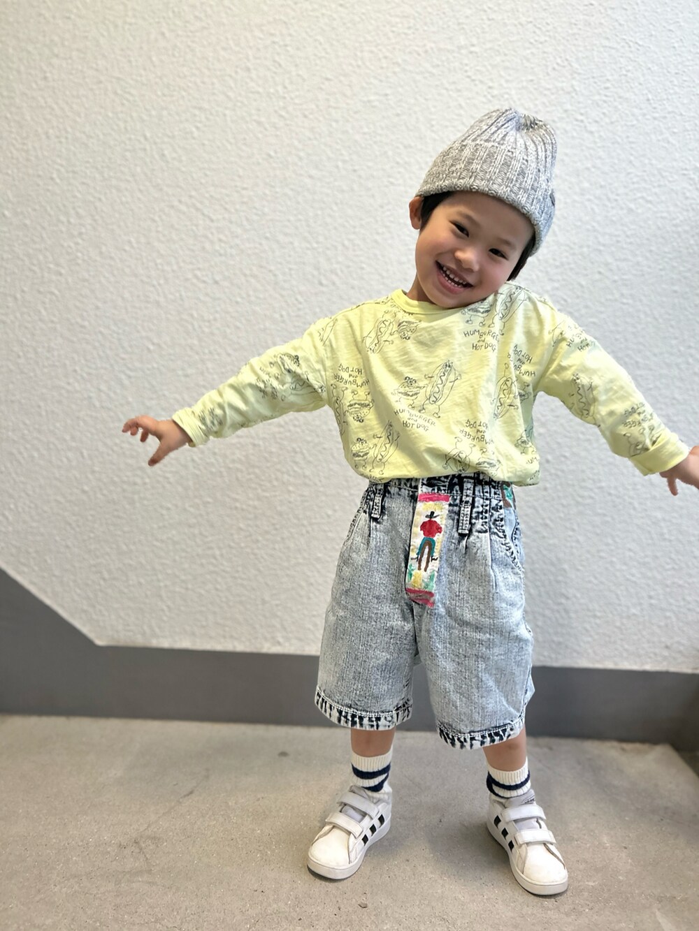 イエロー系のTシャツ/カットソー、ブルー系のデニムパンツ、ホワイト系のスニーカーを着用したキッズの冬コーディネートの2枚目の写真