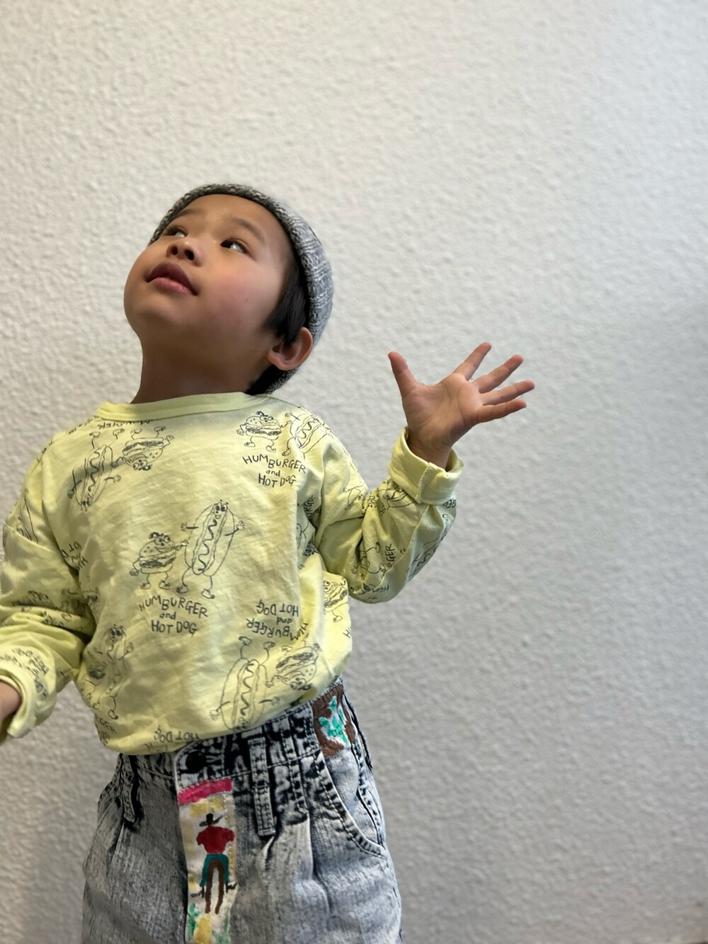 イエロー系のTシャツ/カットソー、ブルー系のデニムパンツ、ホワイト系のスニーカーを着用したキッズの冬コーディネートの3枚目の写真