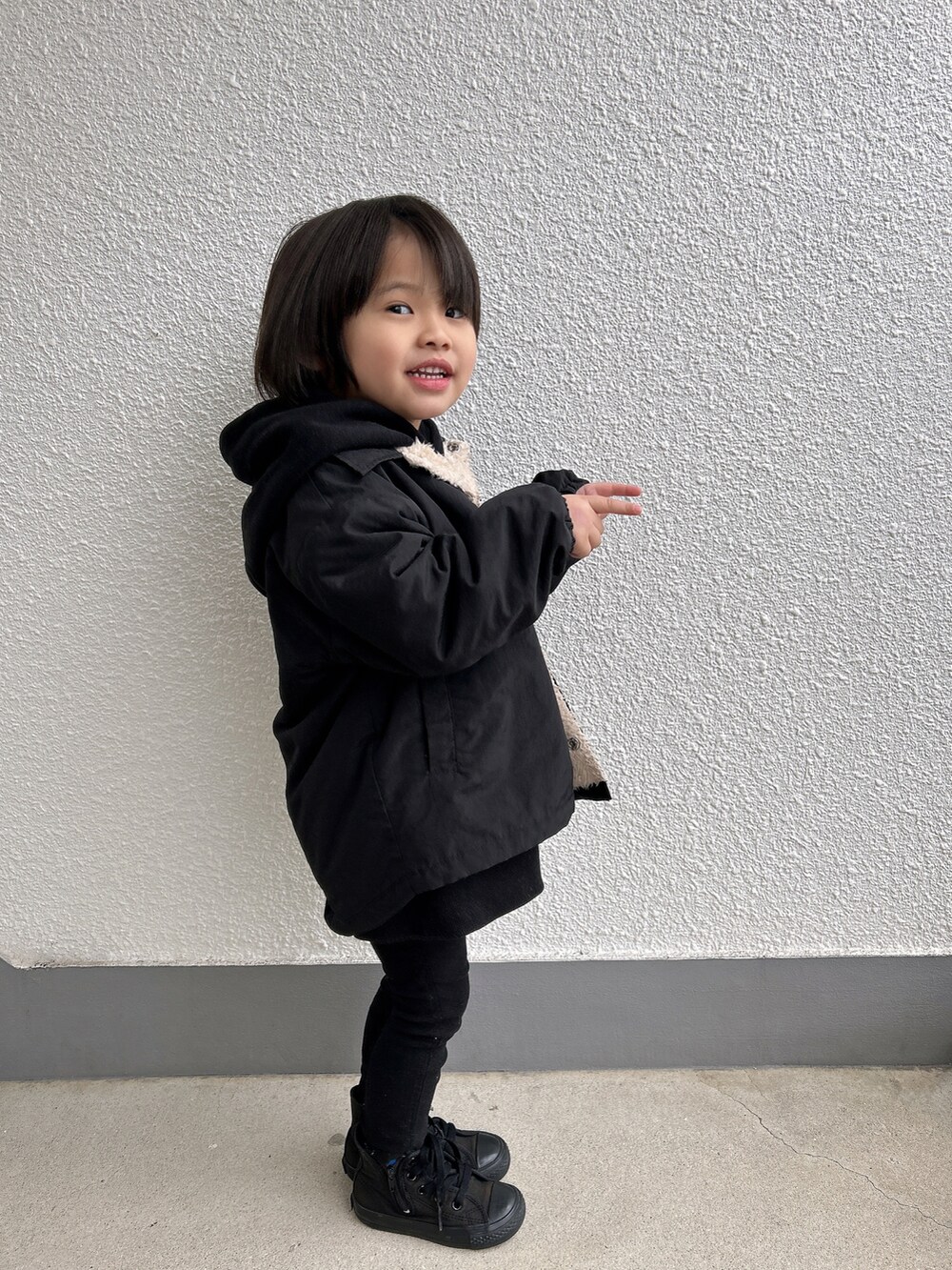 ブラック系のナイロンジャケット、ブラック系のその他パンツ、ブラック系のスニーカーを着用したキッズの冬コーディネートの2枚目の写真