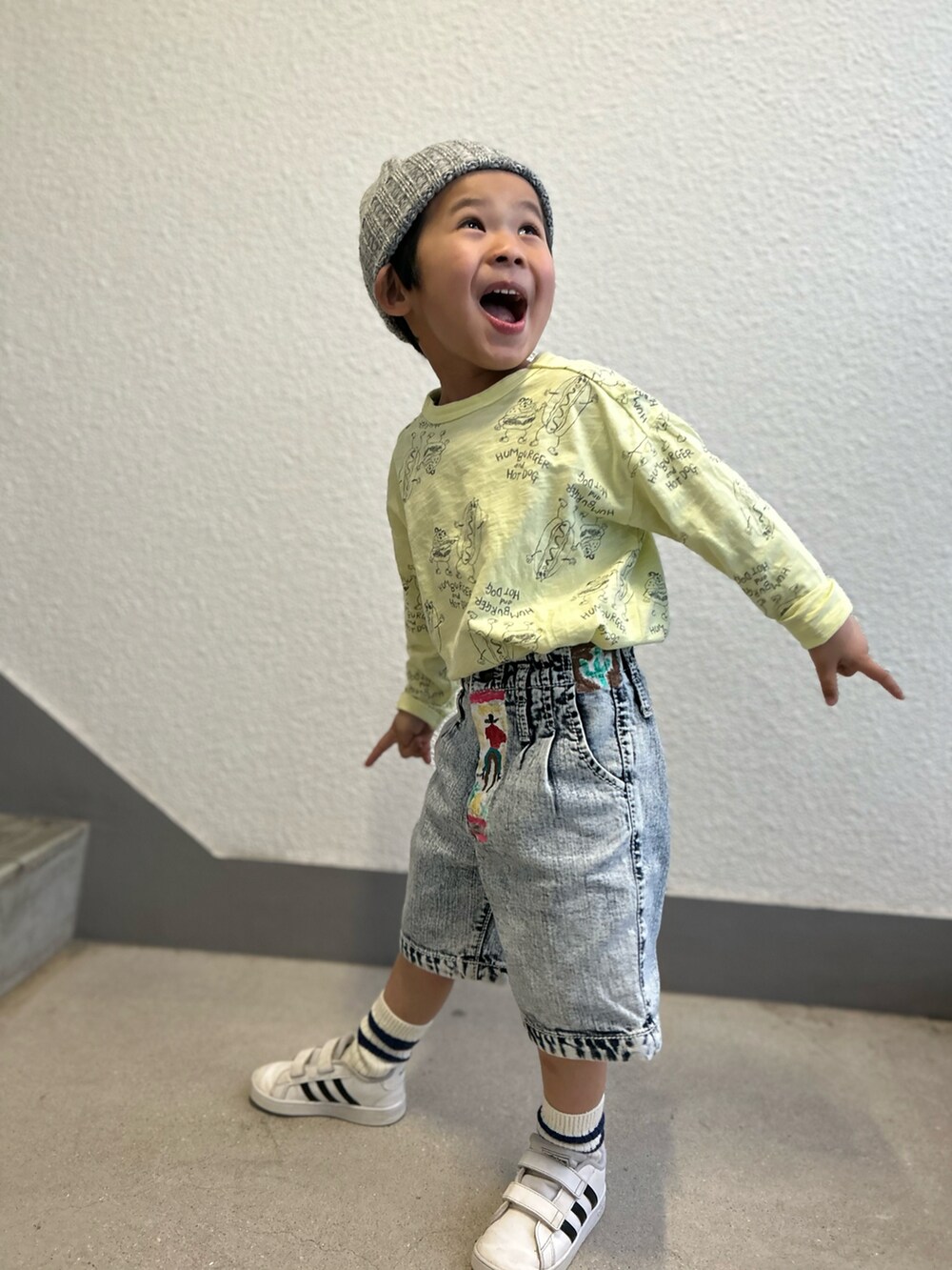 イエロー系のTシャツ/カットソー、ブルー系のデニムパンツ、ホワイト系のスニーカーを着用したキッズの冬コーディネートの5枚目の写真