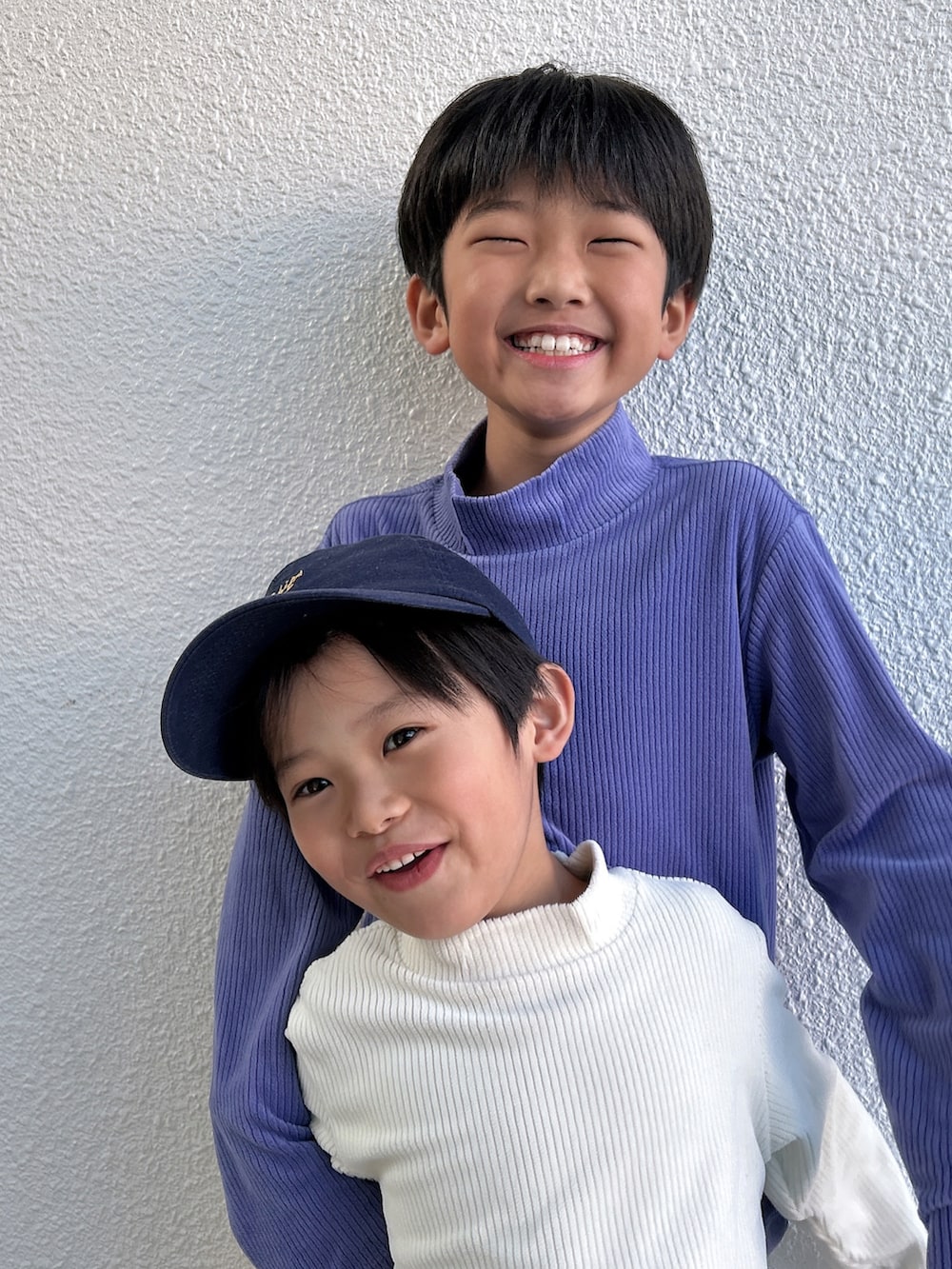 パープル系のTシャツ/カットソー、ホワイト系のデニムパンツ、ホワイト系のスニーカーを着用したキッズの冬コーディネートの2枚目の写真