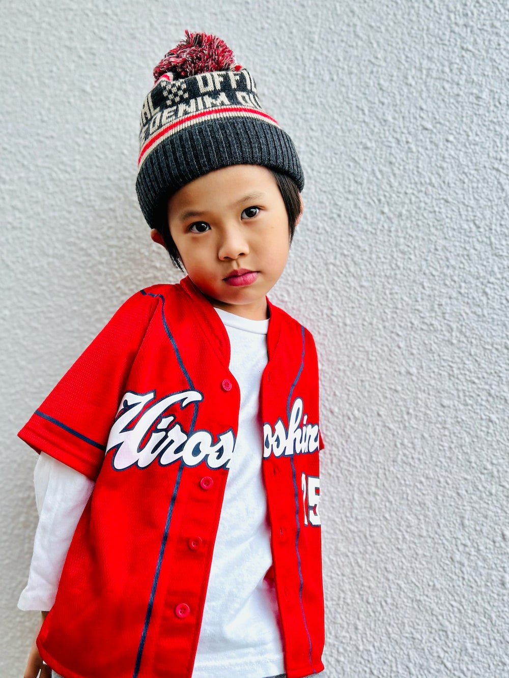 グレー系のスウェットパンツ、グレー系のニットキャップ/ビーニー、レッド系のスポーツグッズを着用したキッズの秋コーディネートの2枚目の写真