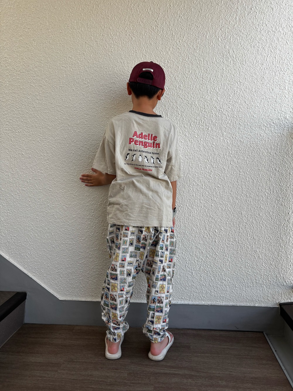 グレー系のTシャツ/カットソー、ホワイト系のパンツ、レッド系のキャップを着用したキッズの秋コーディネートの2枚目の写真