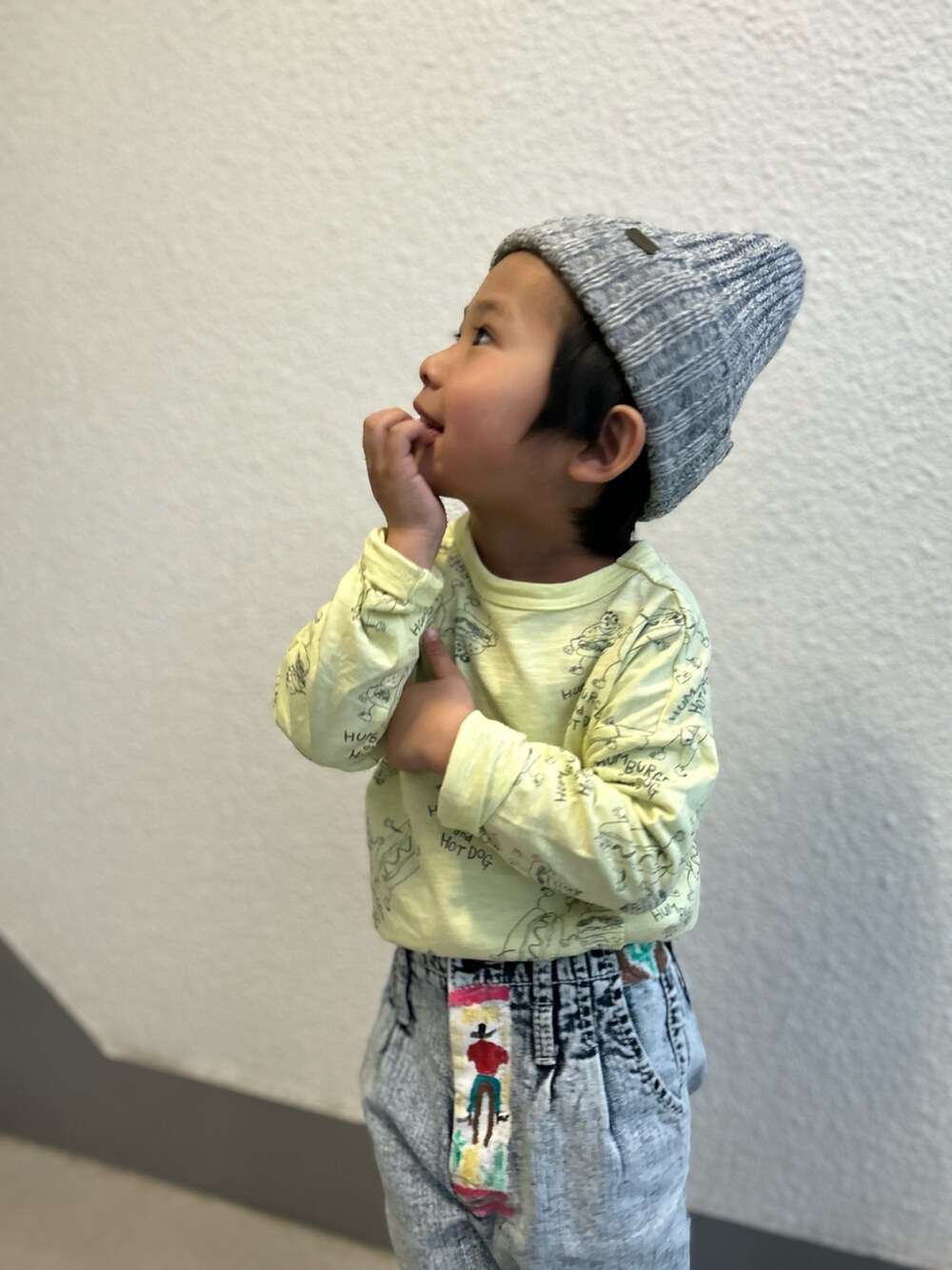 イエロー系のTシャツ/カットソー、ブルー系のデニムパンツ、ホワイト系のスニーカーを着用したキッズの冬コーディネートの4枚目の写真