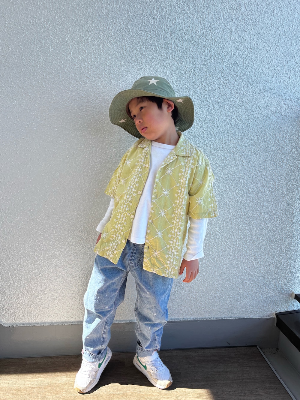 ブルー系のデニムパンツ、グリーン系のスニーカー、イエロー系のシャツ/ブラウスを着用したキッズの春コーディネートの2枚目の写真