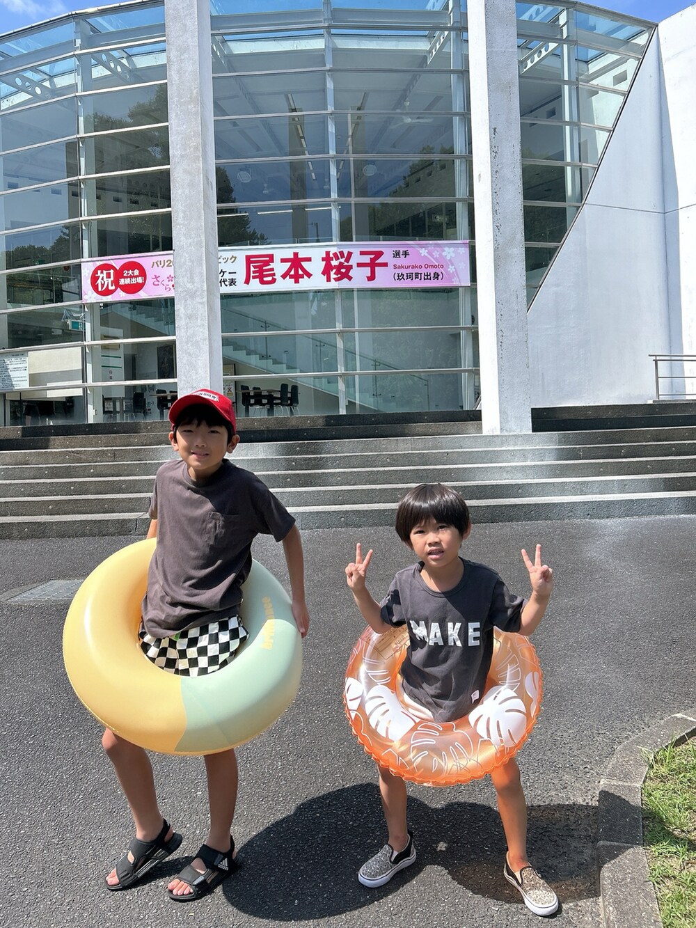 グレー系のTシャツ/カットソー、ホワイト系のその他パンツ、ブラック系のサンダルを着用したキッズの夏コーディネートの2枚目の写真
