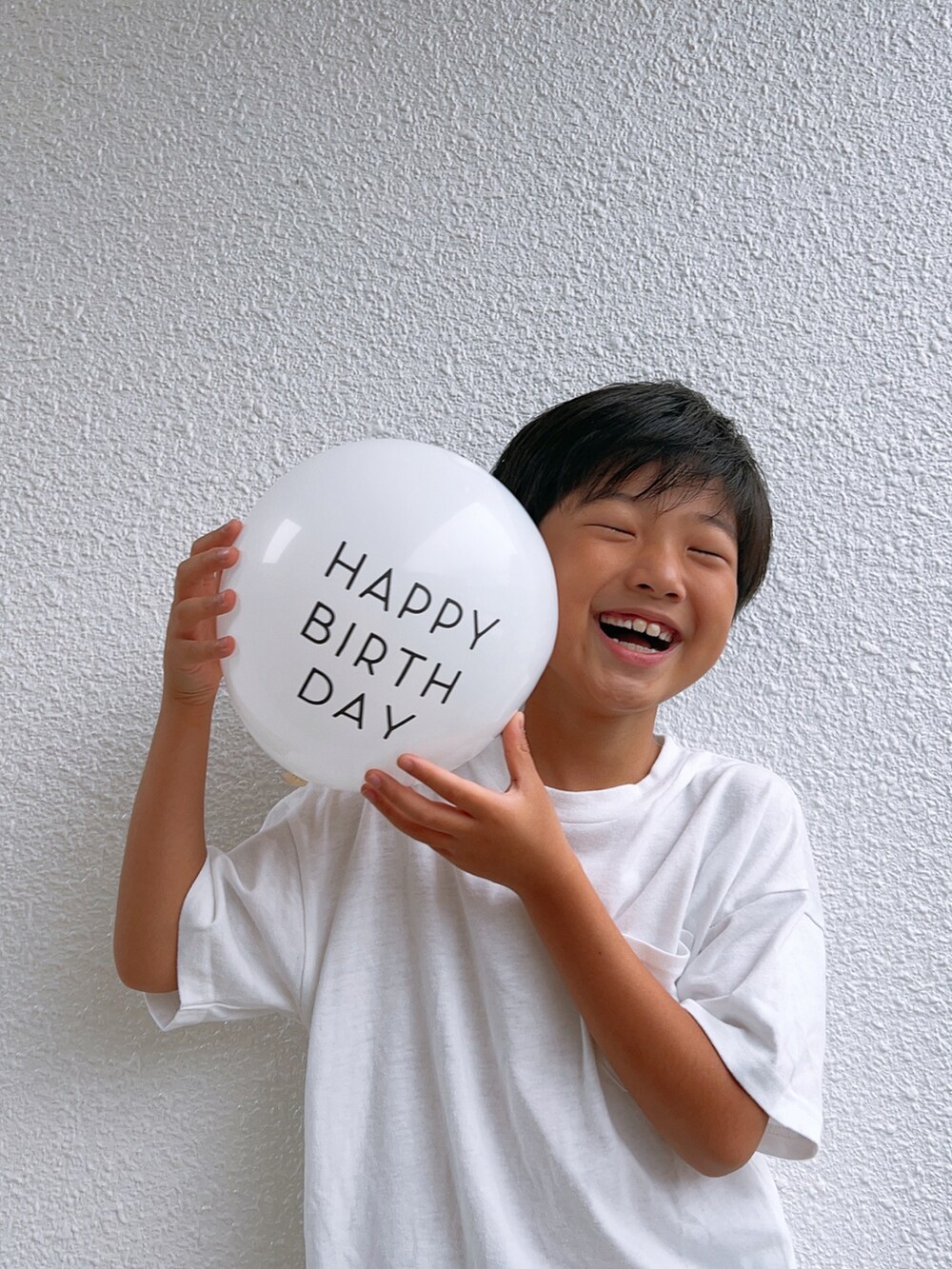 ホワイト系のTシャツ/カットソー、ブルー系のデニムパンツ、ブラック系のサンダルを着用したキッズの夏コーディネートの2枚目の写真