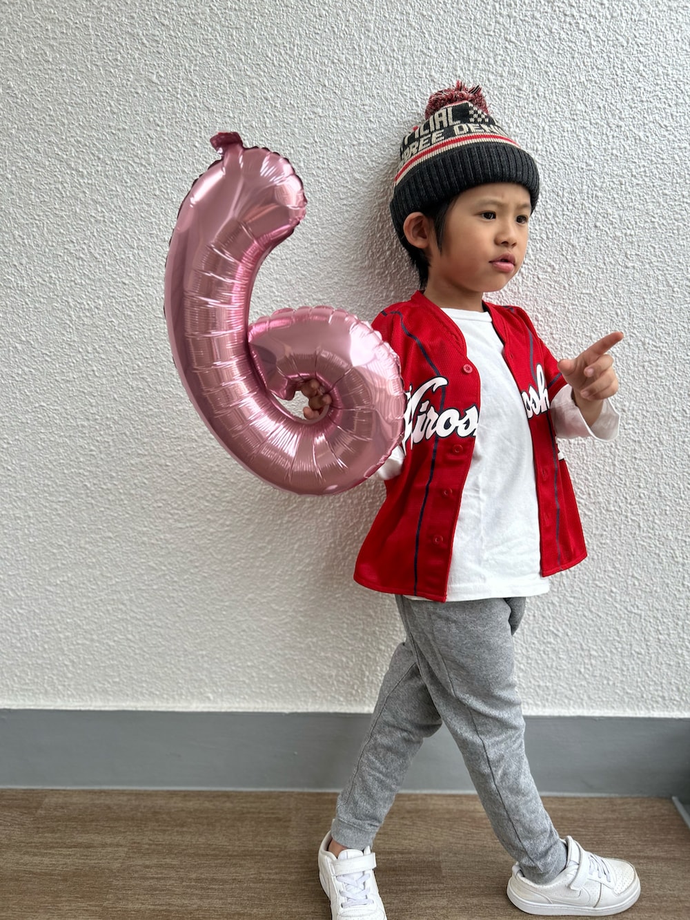 グレー系のスウェットパンツ、グレー系のニットキャップ/ビーニー、レッド系のスポーツグッズを着用したキッズの秋コーディネートの4枚目の写真