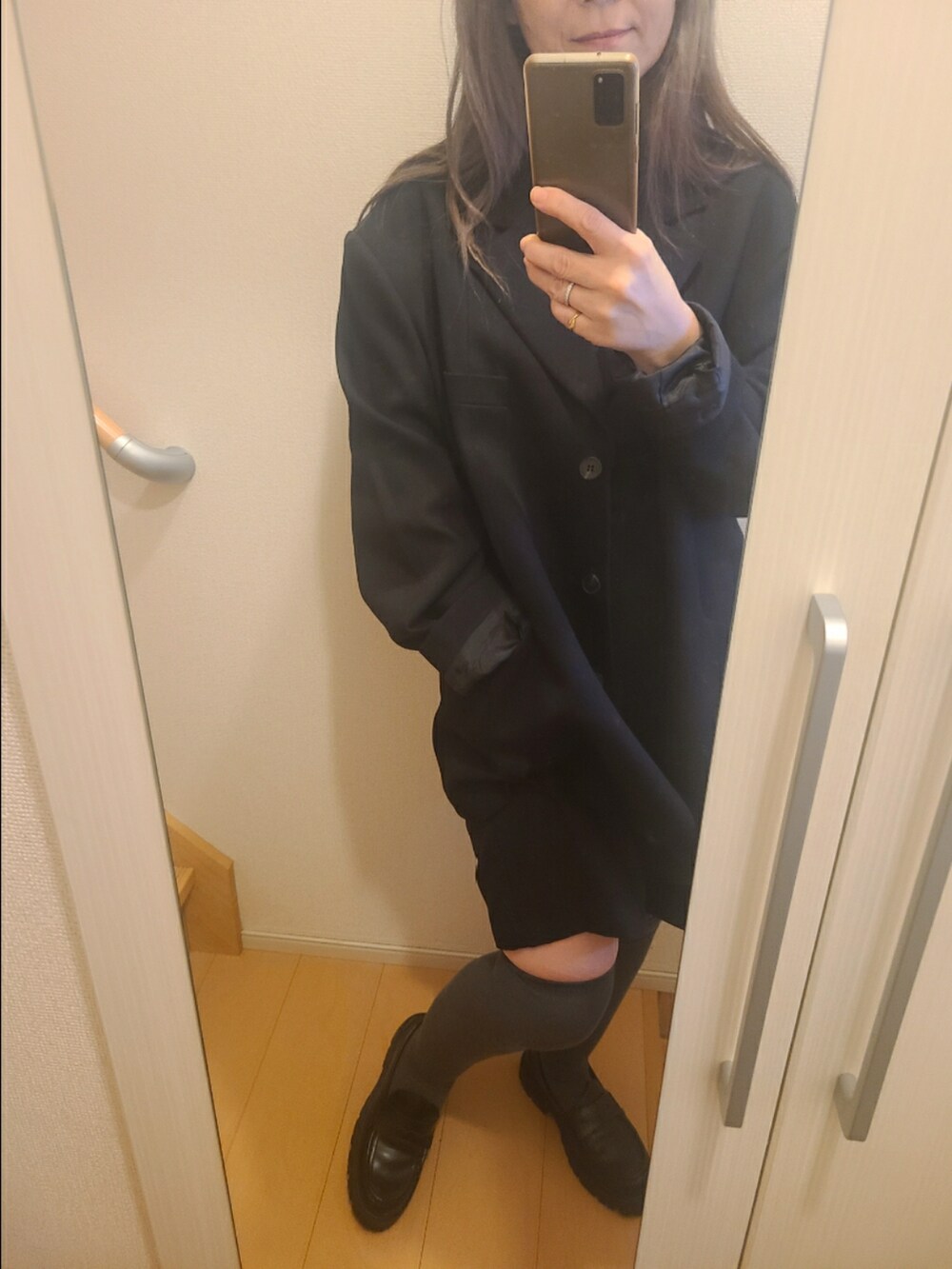 ブラック系のハンドバッグ、ブラック系のローファーを着用したレディースの秋コーディネートの4枚目の写真