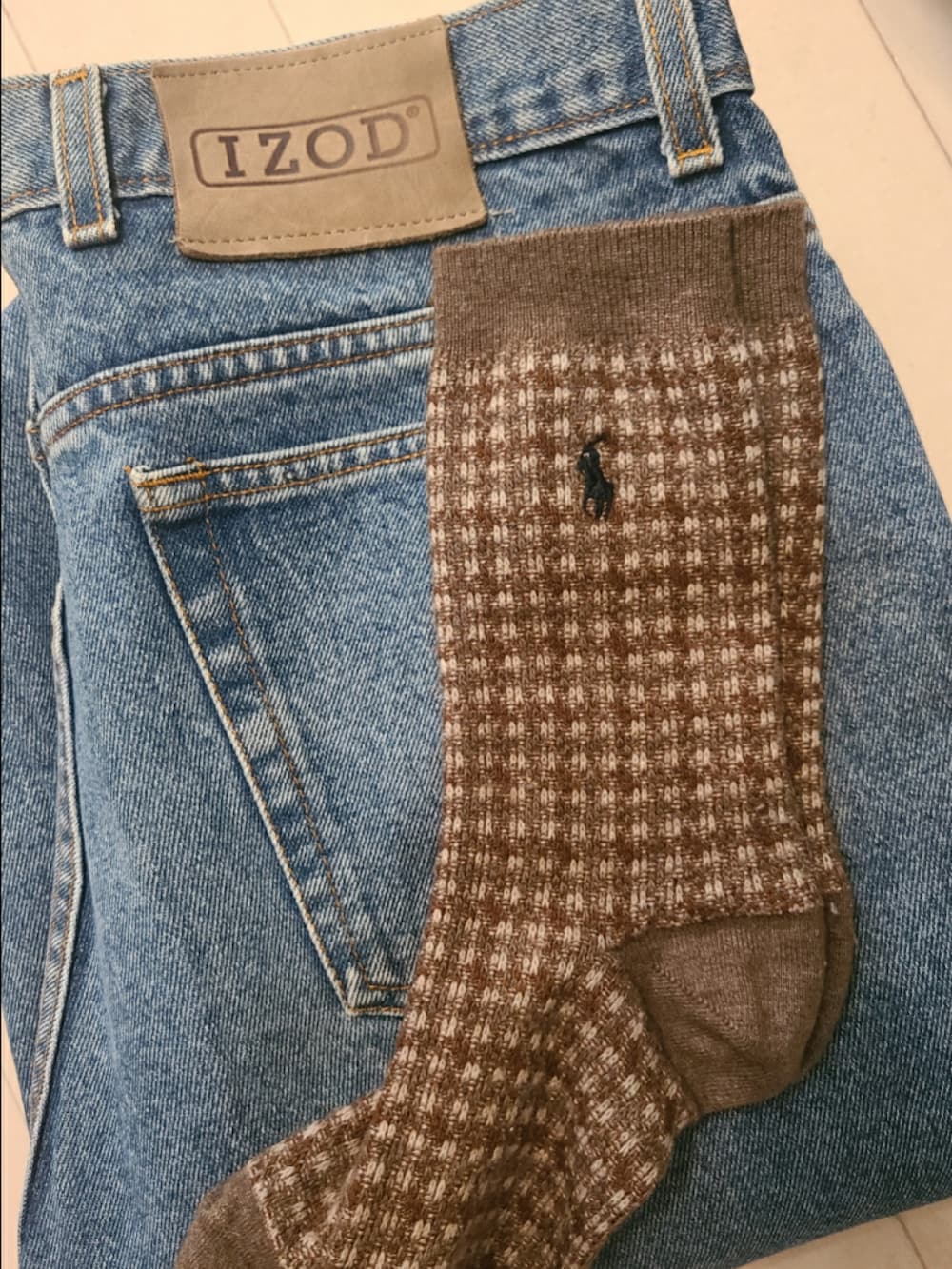 ブルー系のデニムパンツ、ブラック系のブーツ、ベージュ系のトレンチコートを着用したレディースの冬コーディネートの3枚目の写真