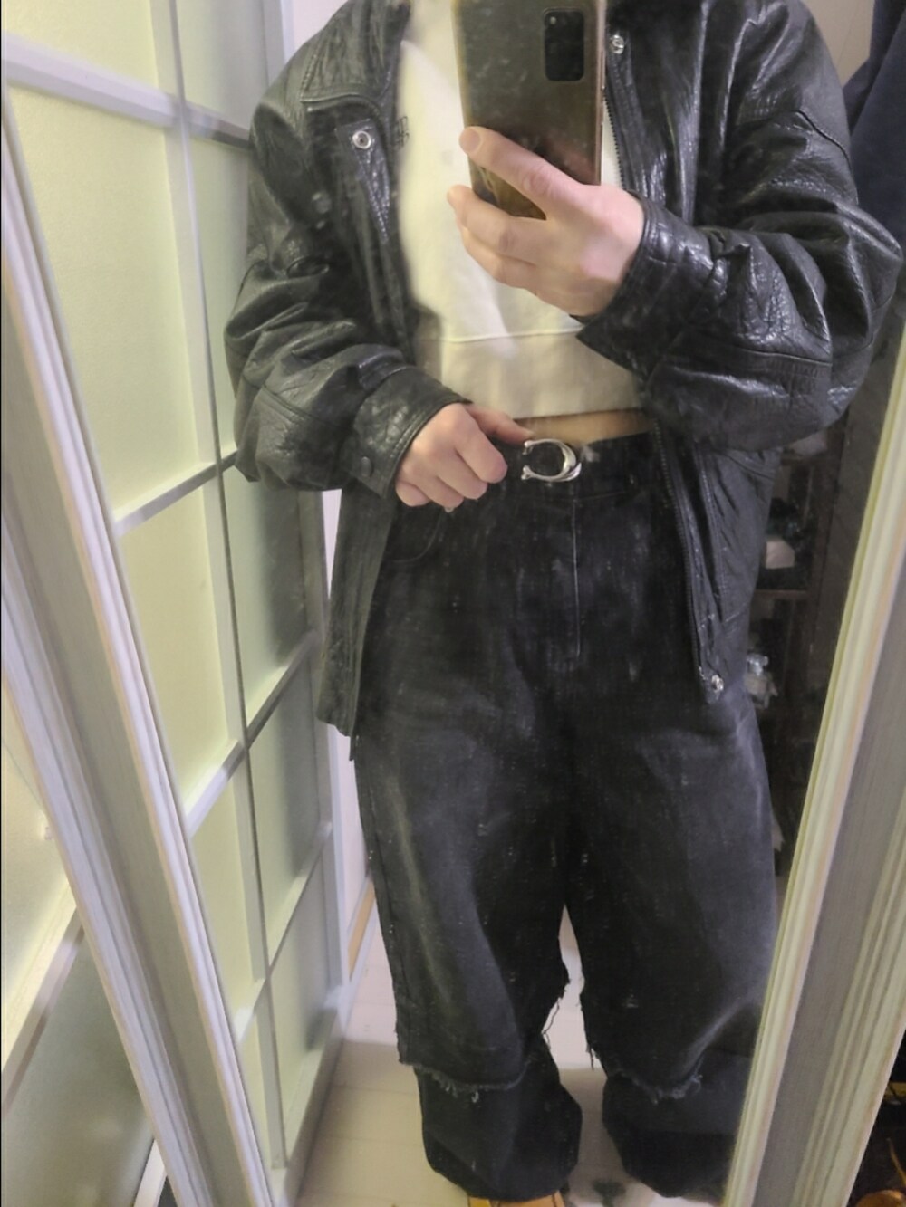 ベージュ系のスウェット、ブラック系のジャケット/アウター、ブラック系のデニムパンツを着用したレディースの冬コーディネートの3枚目の写真