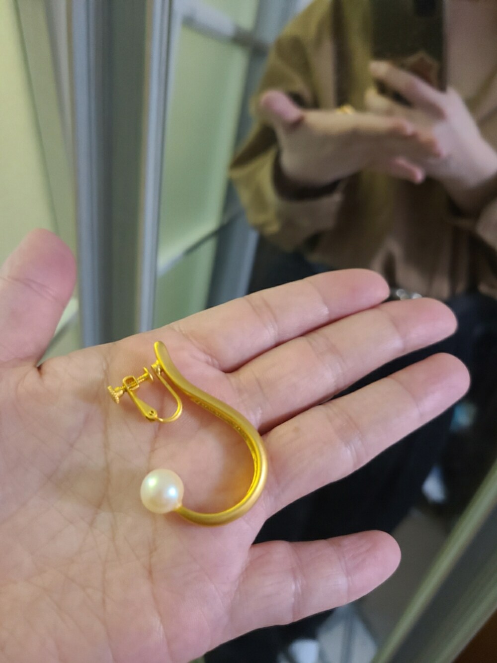 ブラウン系のシャツ/ブラウス、ブラック系のスラックス、ブラック系のバレエシューズを着用したレディースの春コーディネートの3枚目の写真