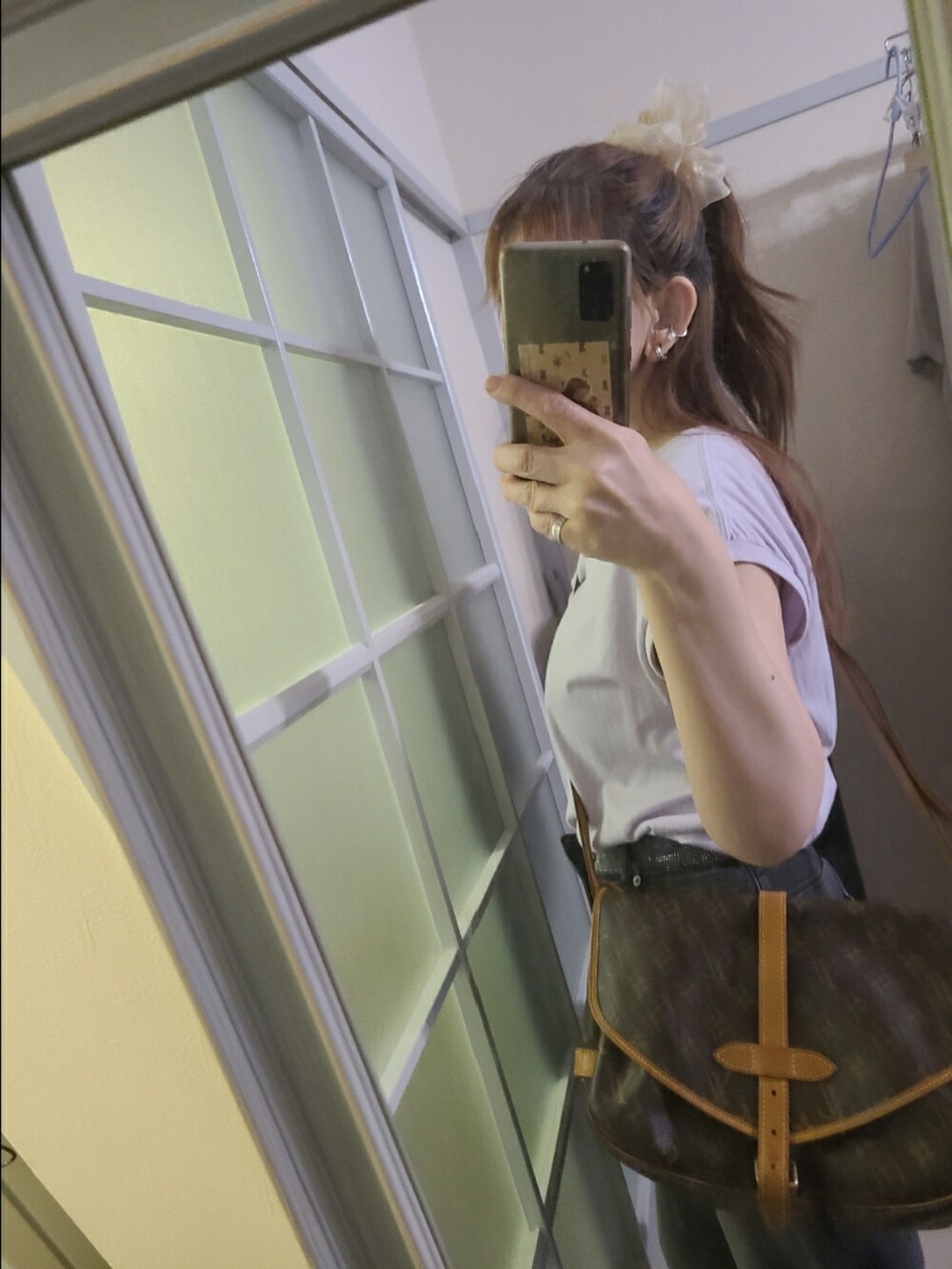 パープル系のタンクトップ、ブラック系のデニムパンツ、ブラック系のスニーカーを着用したレディースの夏コーディネートの2枚目の写真