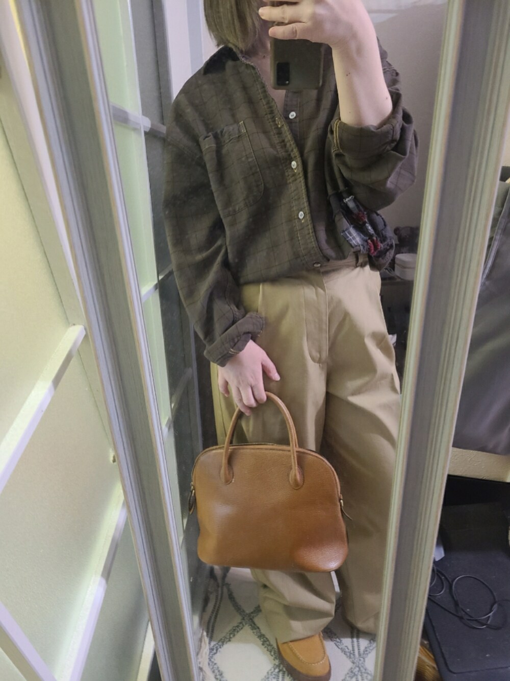 ブラウン系のハンドバッグ、イエロー系のブーツを着用したレディースの春コーディネートの2枚目の写真