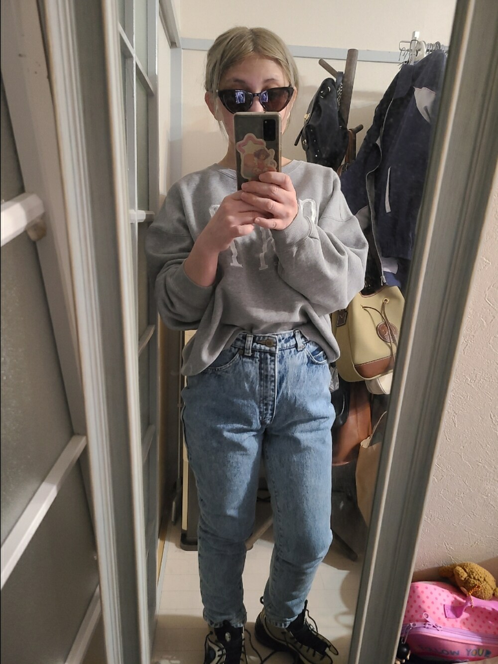 ベージュ系のスニーカー、ブルー系のデニムパンツ、グレー系のスウェットを着用したレディースの冬コーディネートの3枚目の写真