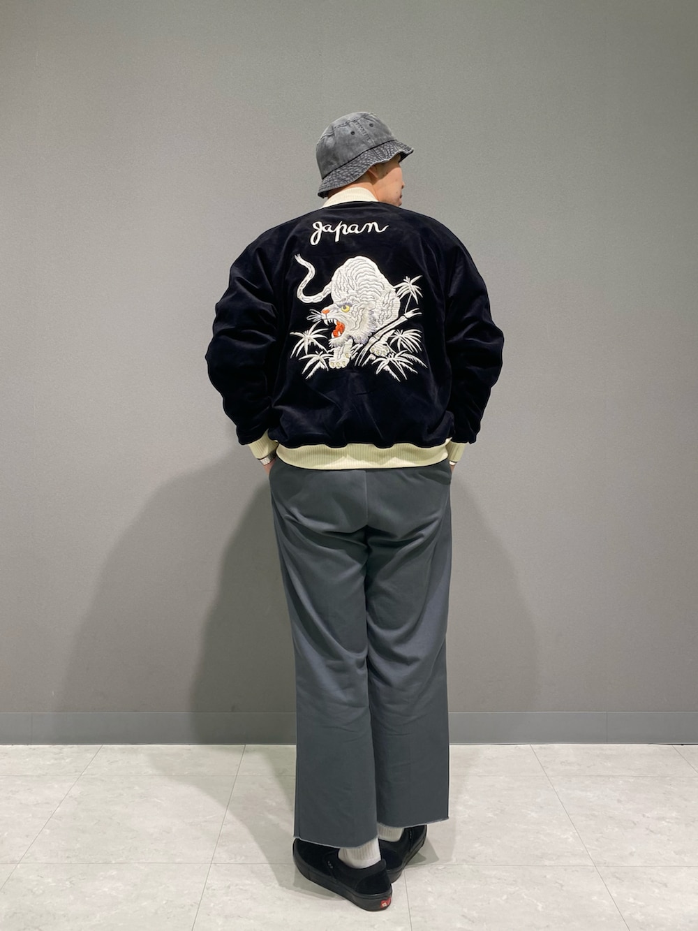 ブラック系のスカジャン、ホワイト系のTシャツ/カットソー、ブラック系のハットを着用したメンズの秋コーディネートの2枚目の写真