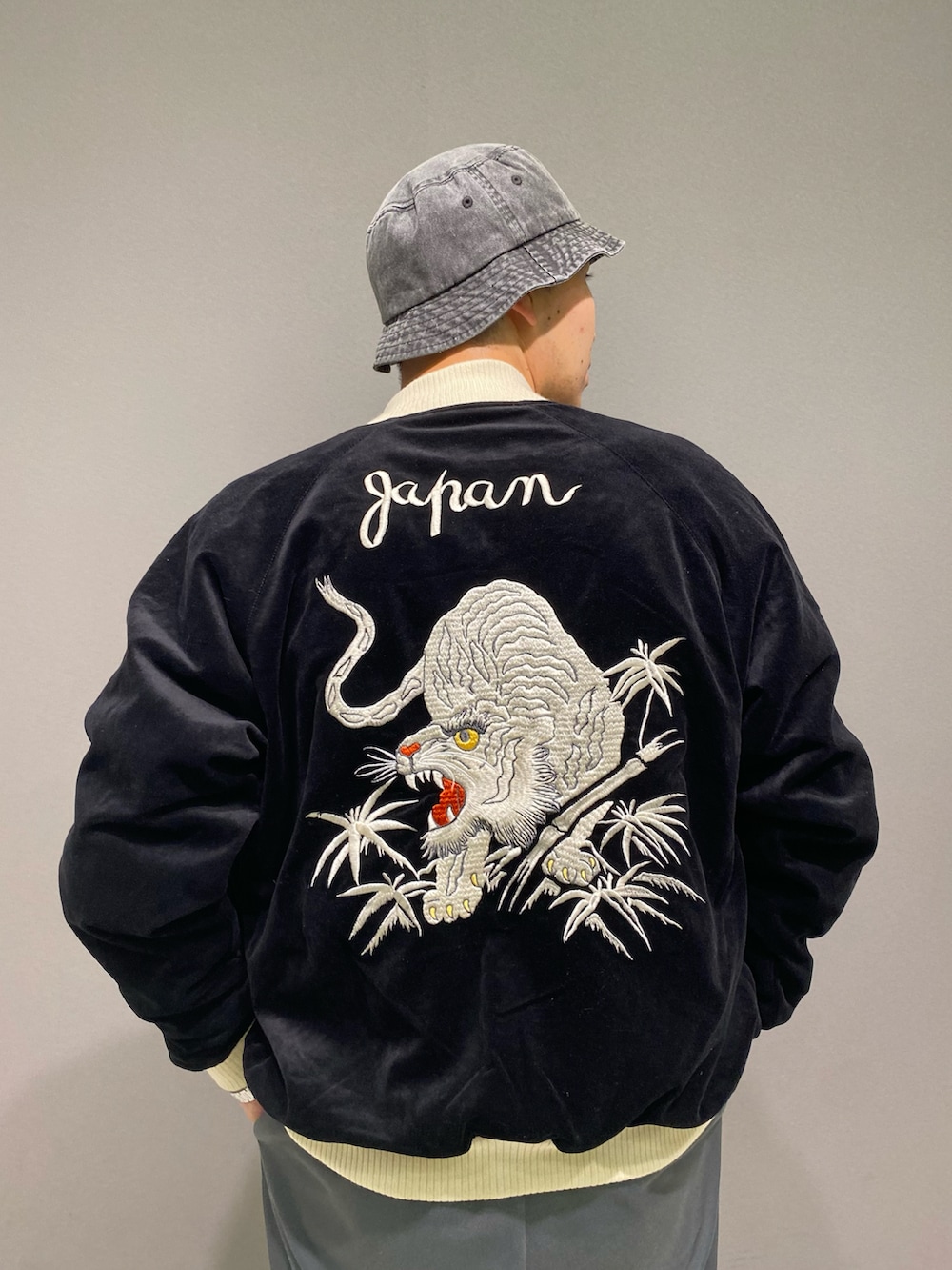 ブラック系のスカジャン、ホワイト系のTシャツ/カットソー、ブラック系のハットを着用したメンズの秋コーディネートの4枚目の写真