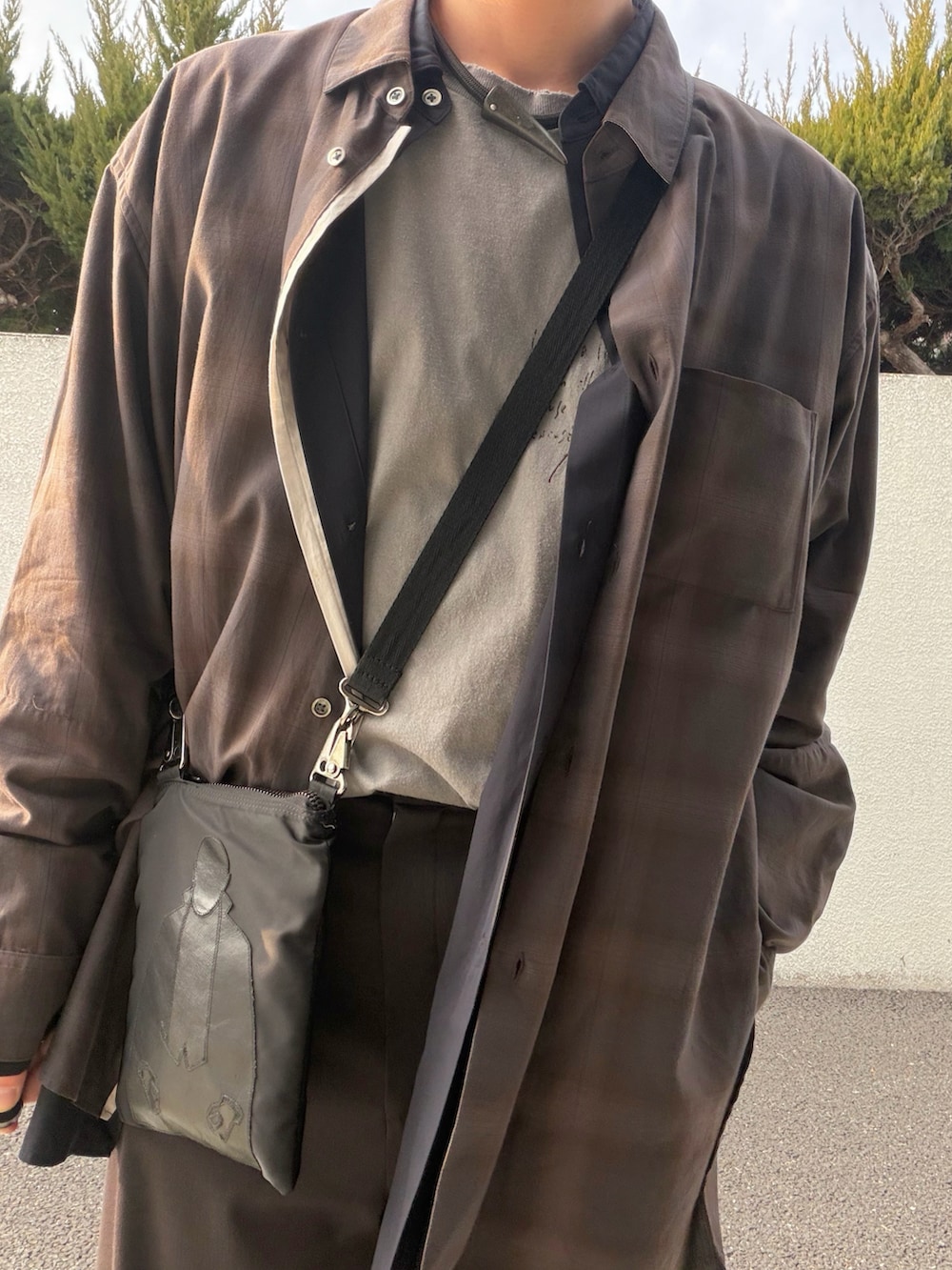 ブラウン系のスラックス、ブラウン系のシャツ/ブラウス、グレー系のTシャツ/カットソーを着用したメンズの冬コーディネートの2枚目の写真