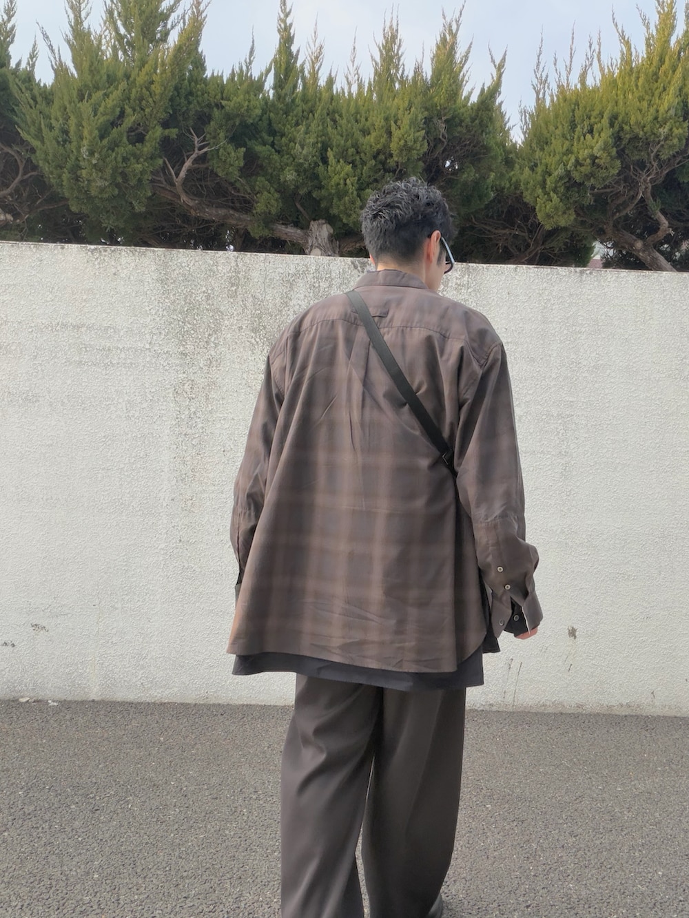 ブラウン系のスラックス、ブラウン系のシャツ/ブラウス、グレー系のTシャツ/カットソーを着用したメンズの冬コーディネートの3枚目の写真