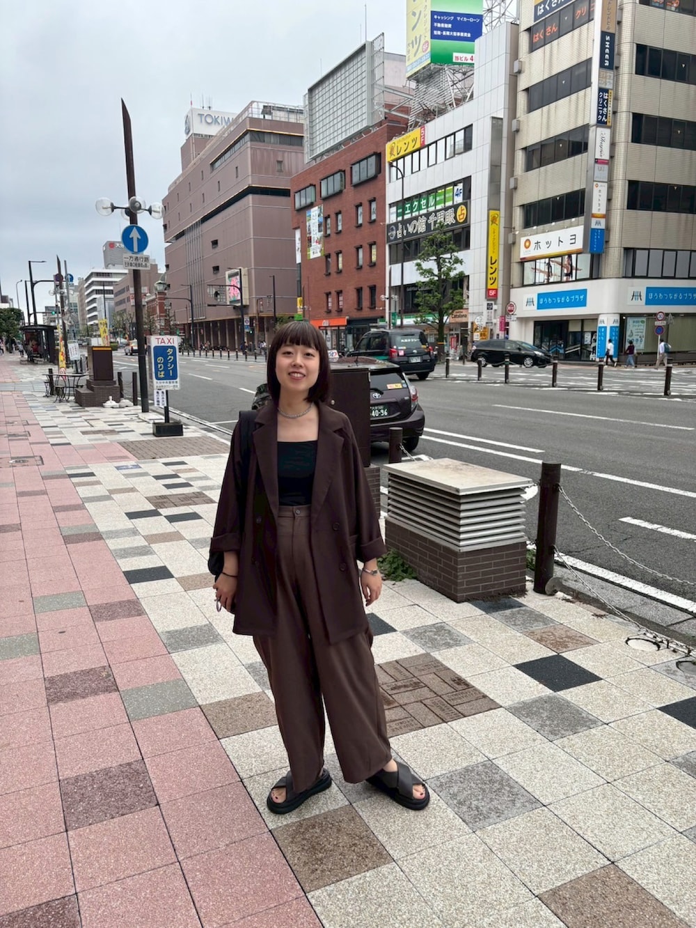 ブラウン系のスラックス、グレー系のサンダルを着用したレディースの秋コーディネートの2枚目の写真