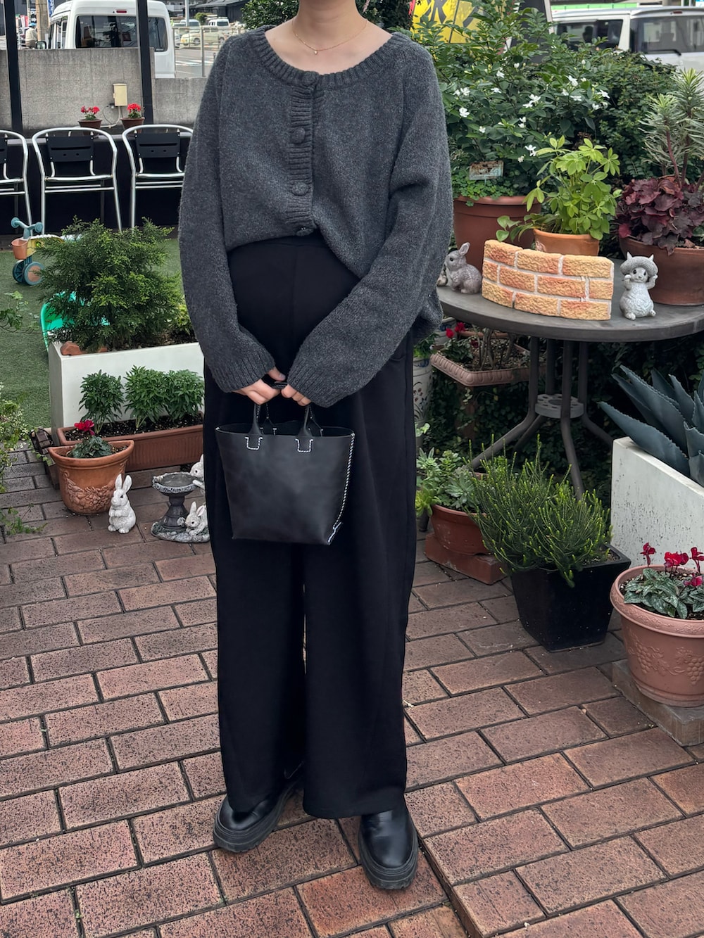 ブラック系のブーツ、グレー系のニット/セーター、ブラック系のパンツを着用したレディースの秋コーディネートの2枚目の写真