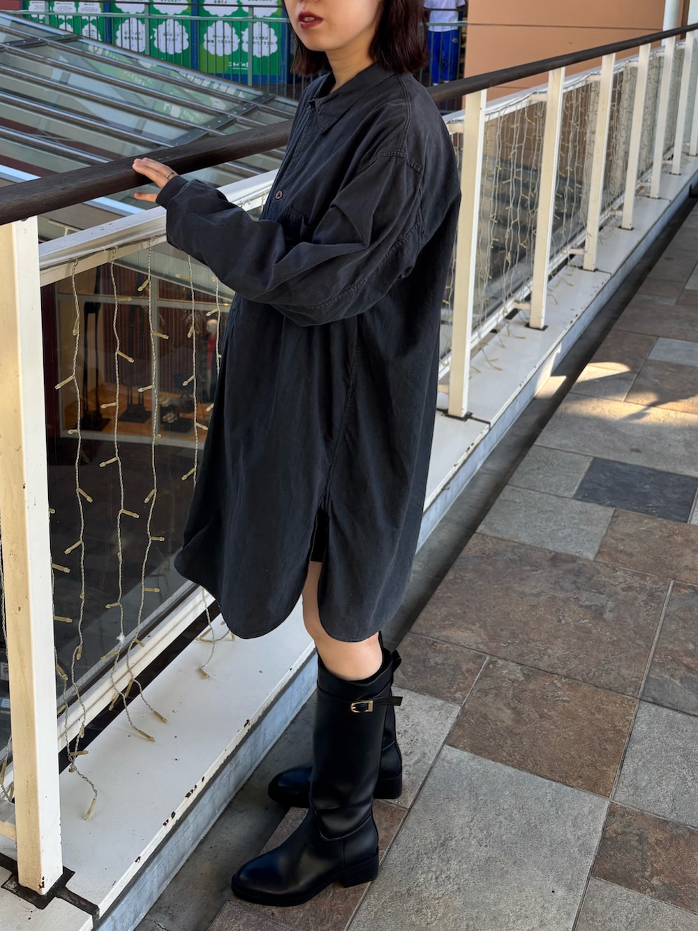 ブラック系のブーツ、ゴールド系のメガネを着用したレディースの秋コーディネートの2枚目の写真