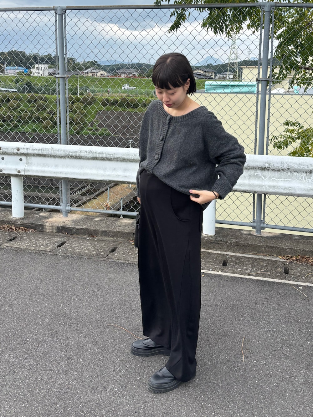 ブラック系のブーツ、グレー系のニット/セーター、ブラック系のパンツを着用したレディースの秋コーディネートの3枚目の写真