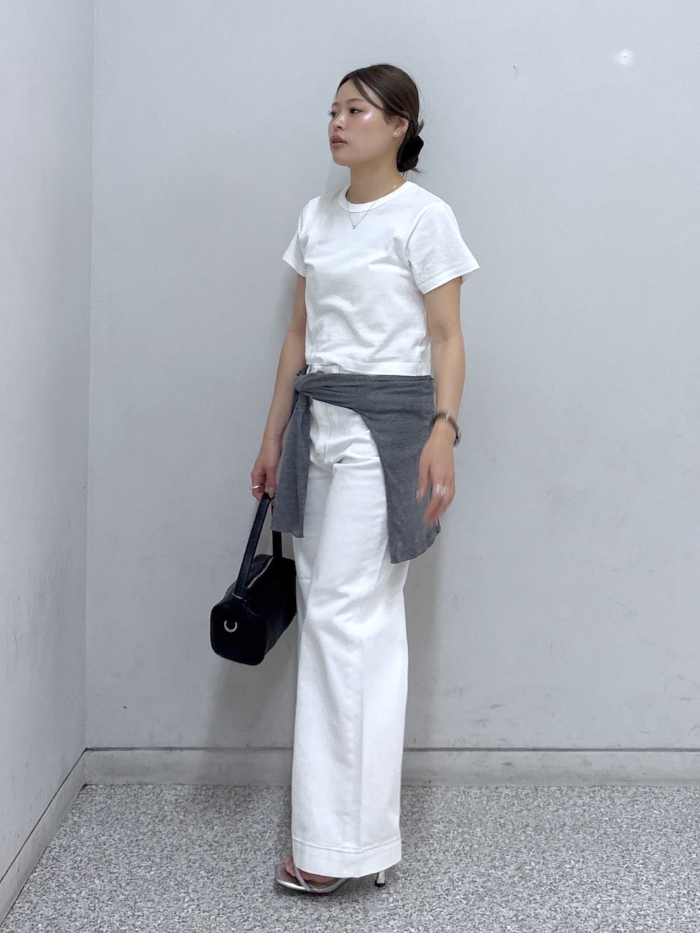 ホワイト系のTシャツ/カットソー、ホワイト系のデニムパンツ、ブラック系のハンドバッグを着用したレディースの夏コーディネートの2枚目の写真