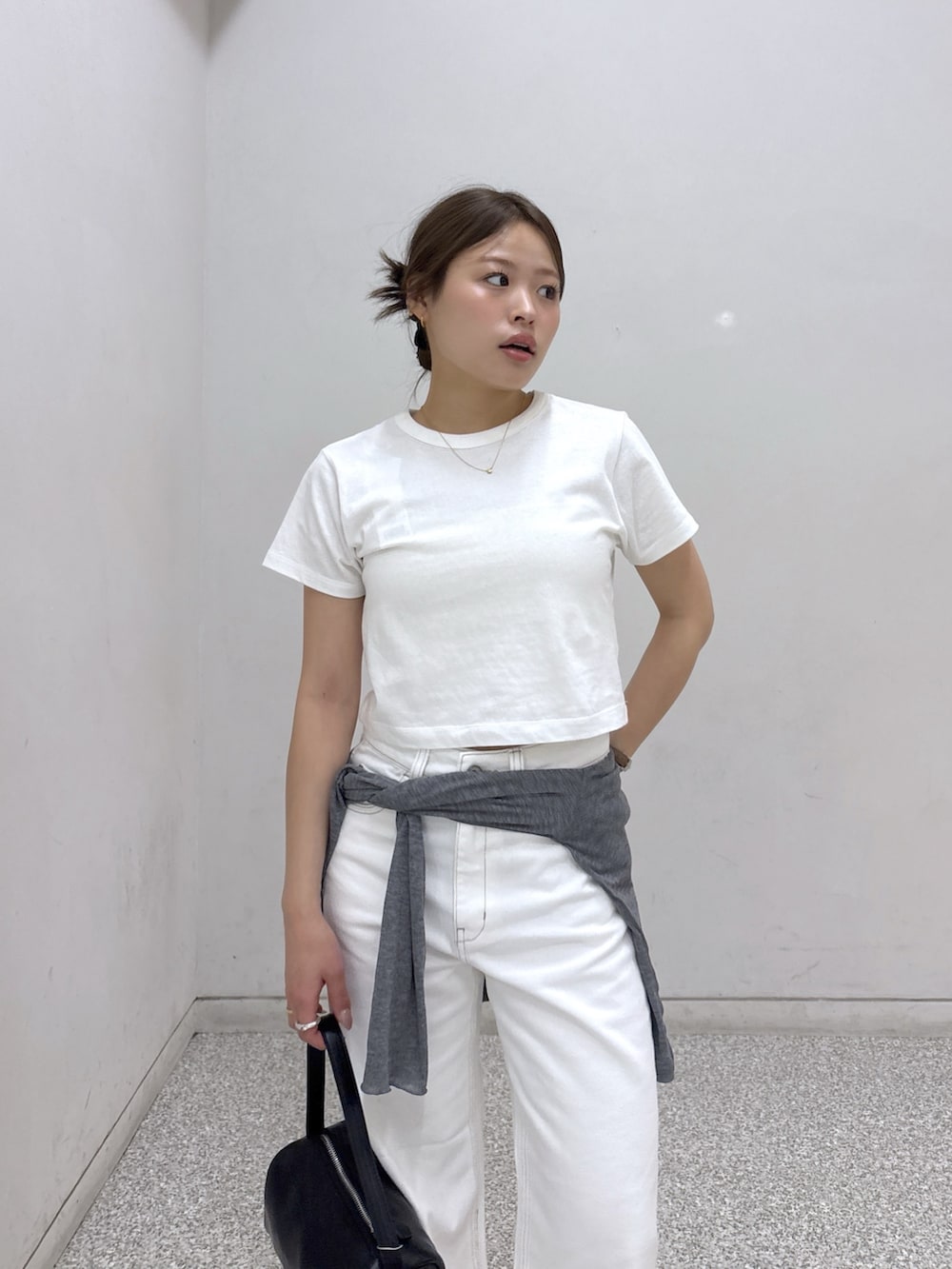 ホワイト系のTシャツ/カットソー、ホワイト系のデニムパンツ、ブラック系のハンドバッグを着用したレディースの夏コーディネートの4枚目の写真