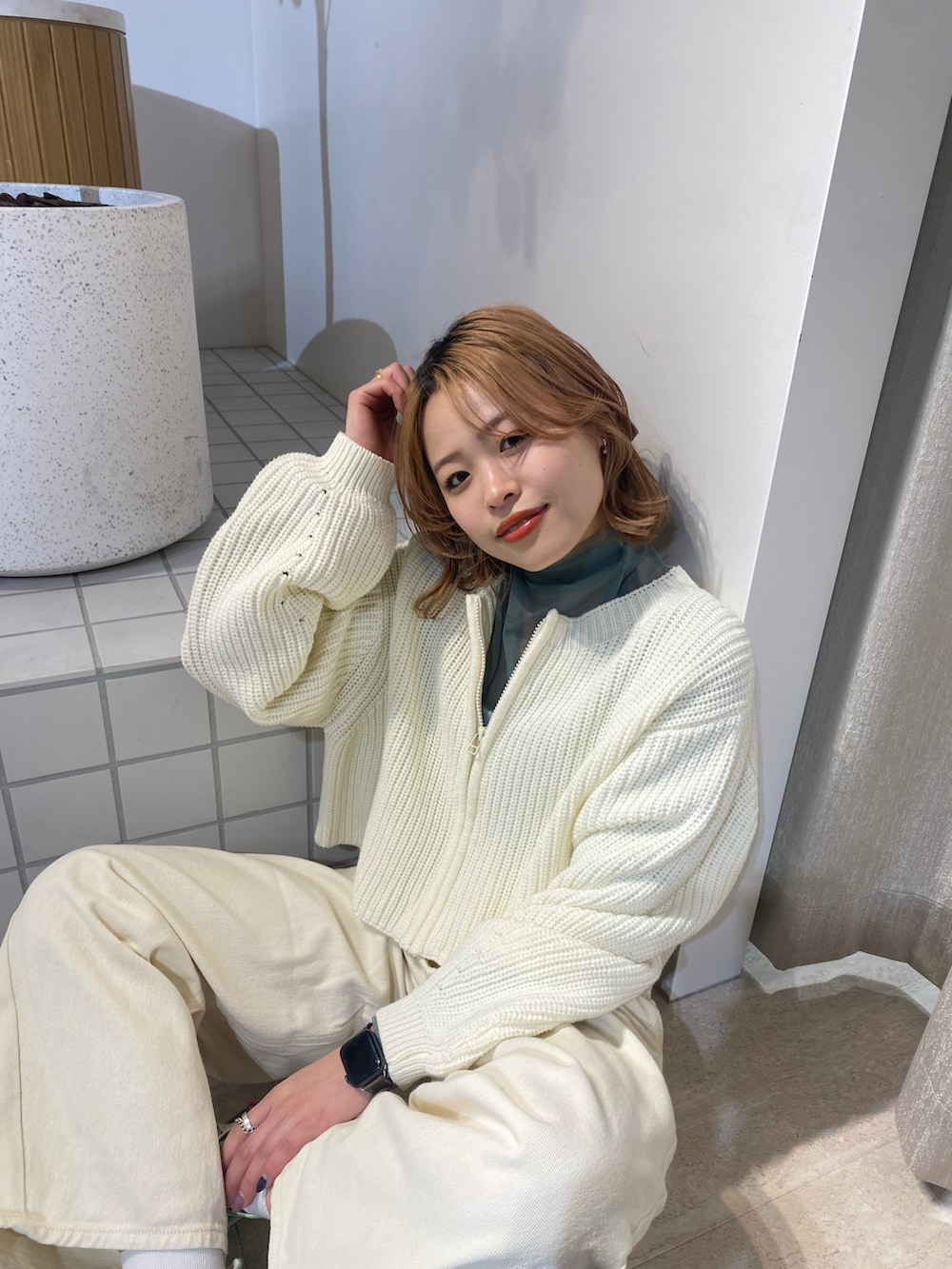 ホワイト系のカーディガン/ボレロ、ホワイト系のデニムパンツ、グリーン系のTシャツ/カットソーを着用したレディースの冬コーディネートの2枚目の写真