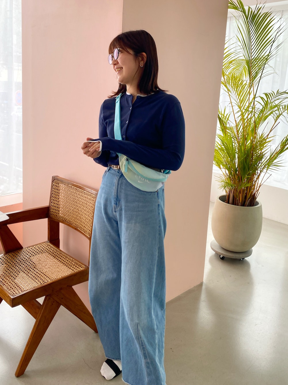 ブルー系のカーディガン/ボレロ、ブルー系のボディバッグ/ウエストポーチ、ブルー系のデニムパンツを着用したレディースの春コーディネートの2枚目の写真