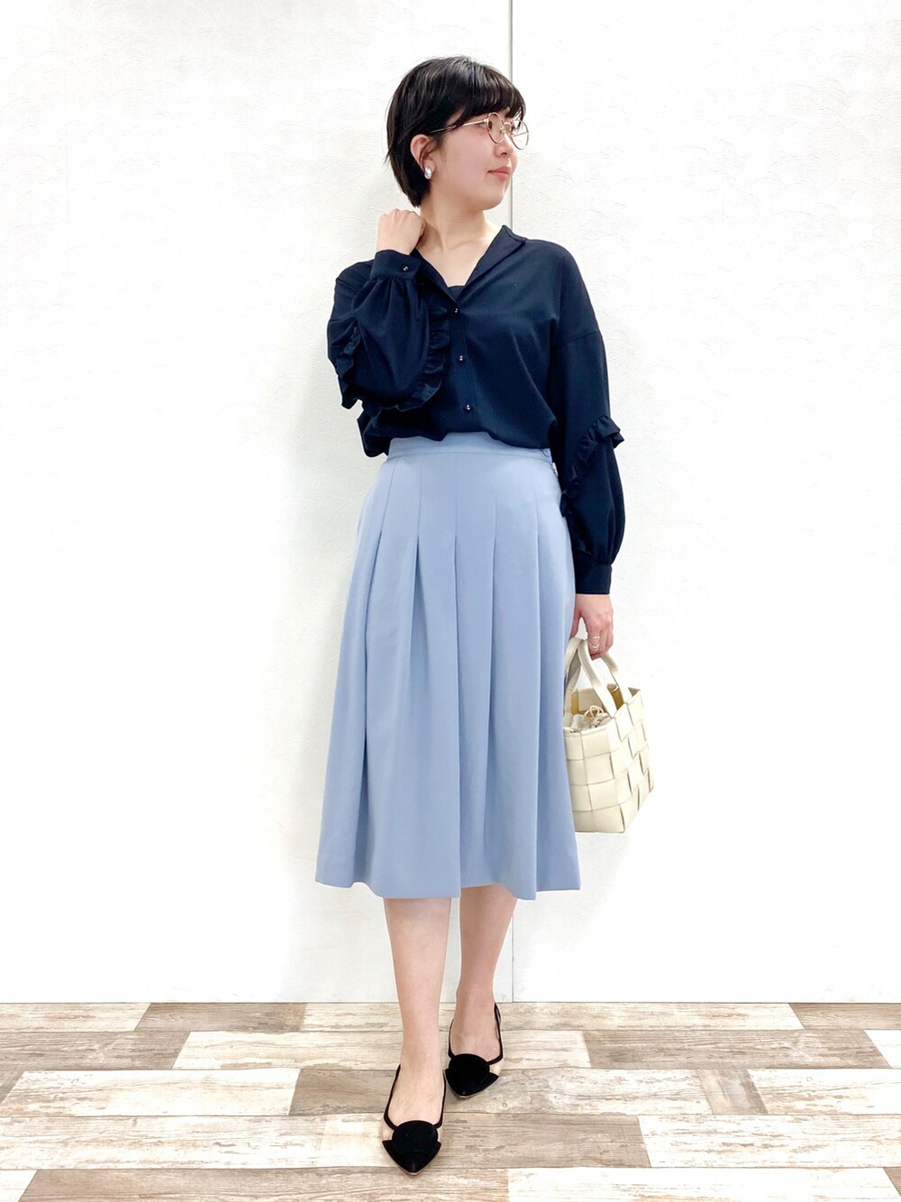 ブラック系のシャツ/ブラウス、ブルー系のスカート、ベージュ系のバッグを着用したレディースの冬コーディネートの5枚目の写真