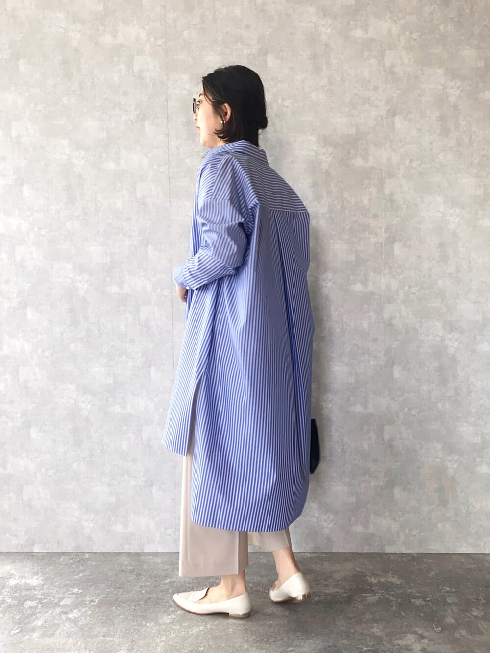 ブルー系のシャツワンピース、ブルー系のTシャツ/カットソー、ベージュ系のパンツを着用したレディースの春コーディネートの2枚目の写真