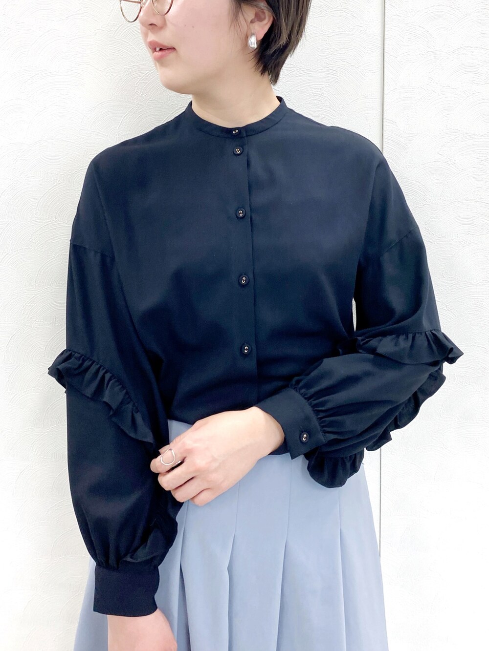 ブラック系のシャツ/ブラウス、ブルー系のスカート、ベージュ系のバッグを着用したレディースの冬コーディネートの2枚目の写真